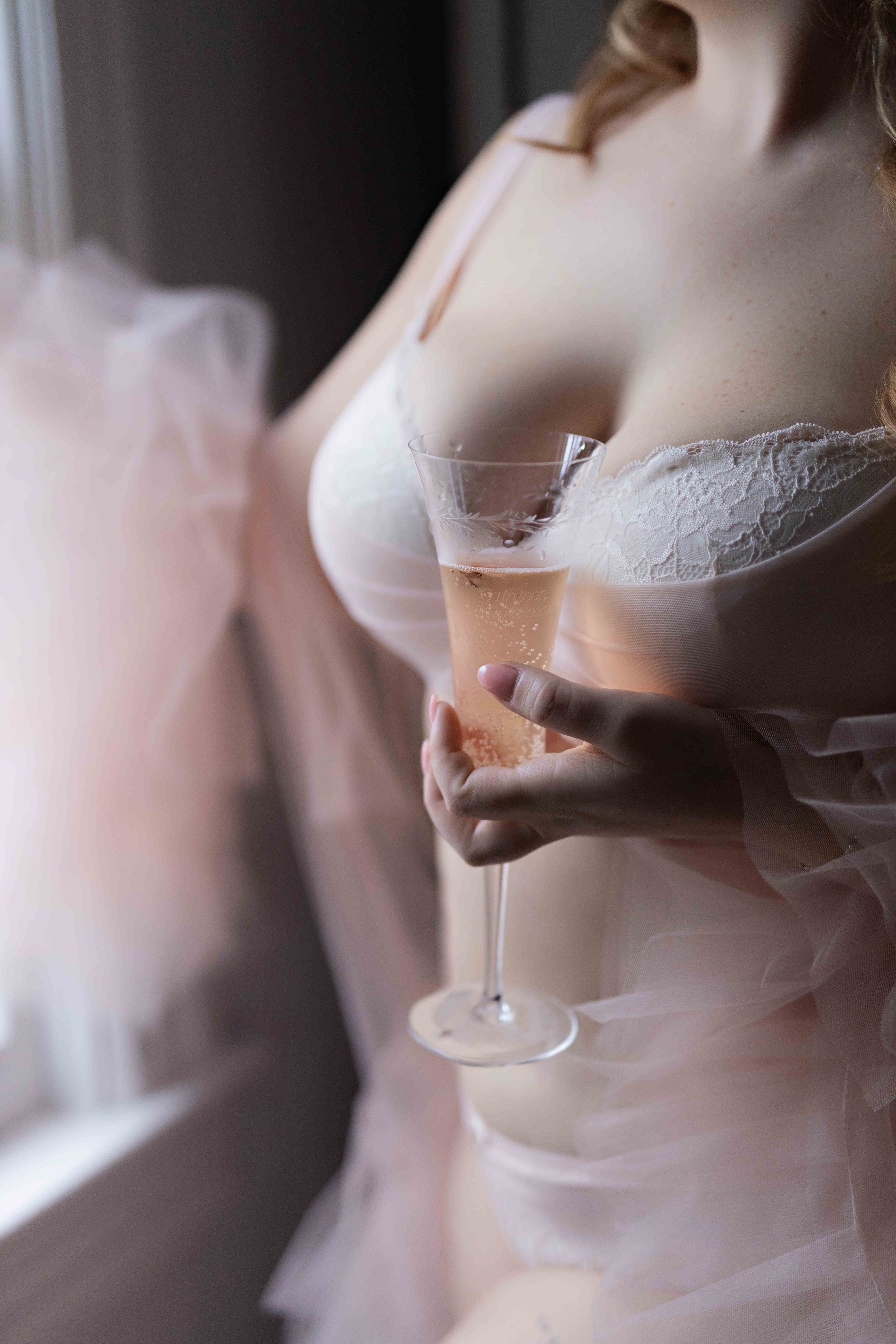 A woman in lingerie in NJ Boudoir photo shoot with champagne glass.