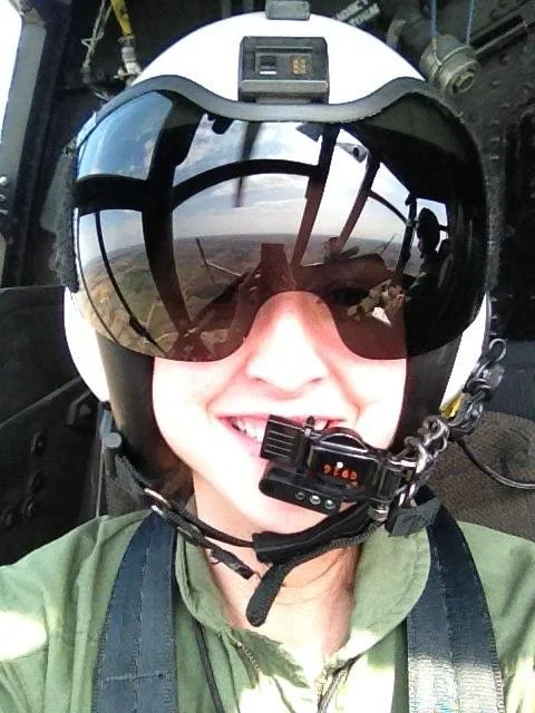 Mackalynn J. Harmon in a helicopter cockpit wearing flight equipment