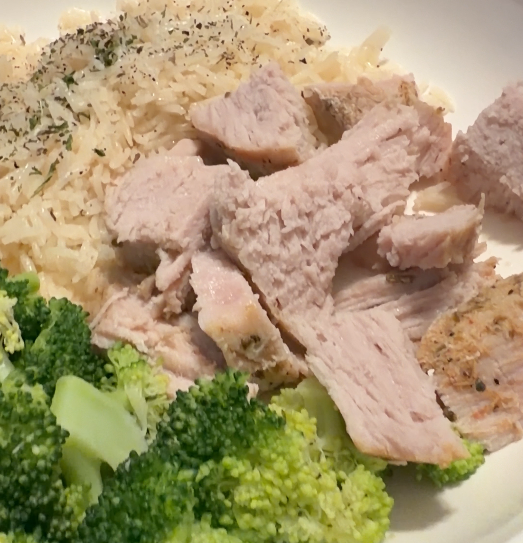 Plate with cooked chicken breast, steamed broccoli, and rice