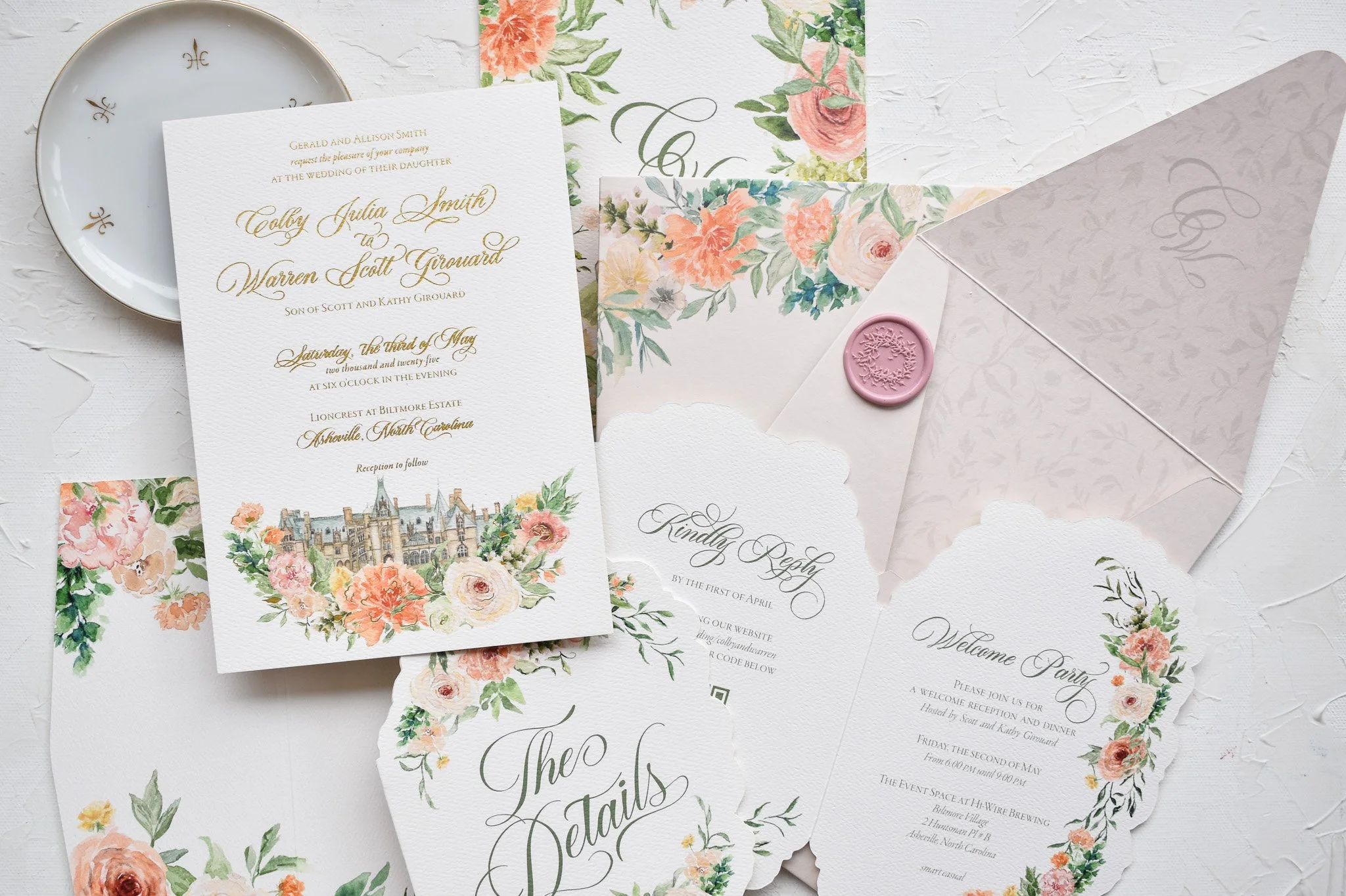A collection of wedding invitations, RSVP card, and floral stationery with pastel and floral designs, a pink wax seal, and a small decorative plate.