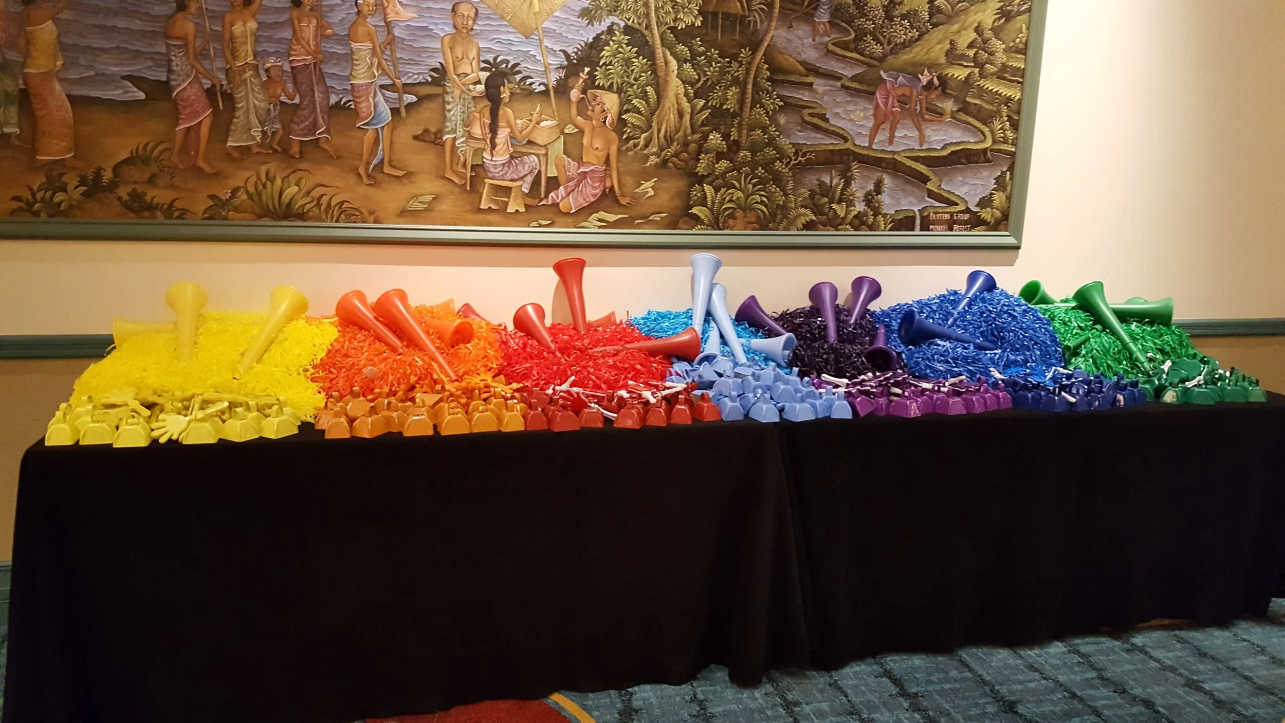 table covered in colorful horns, pompoms, and cowbells