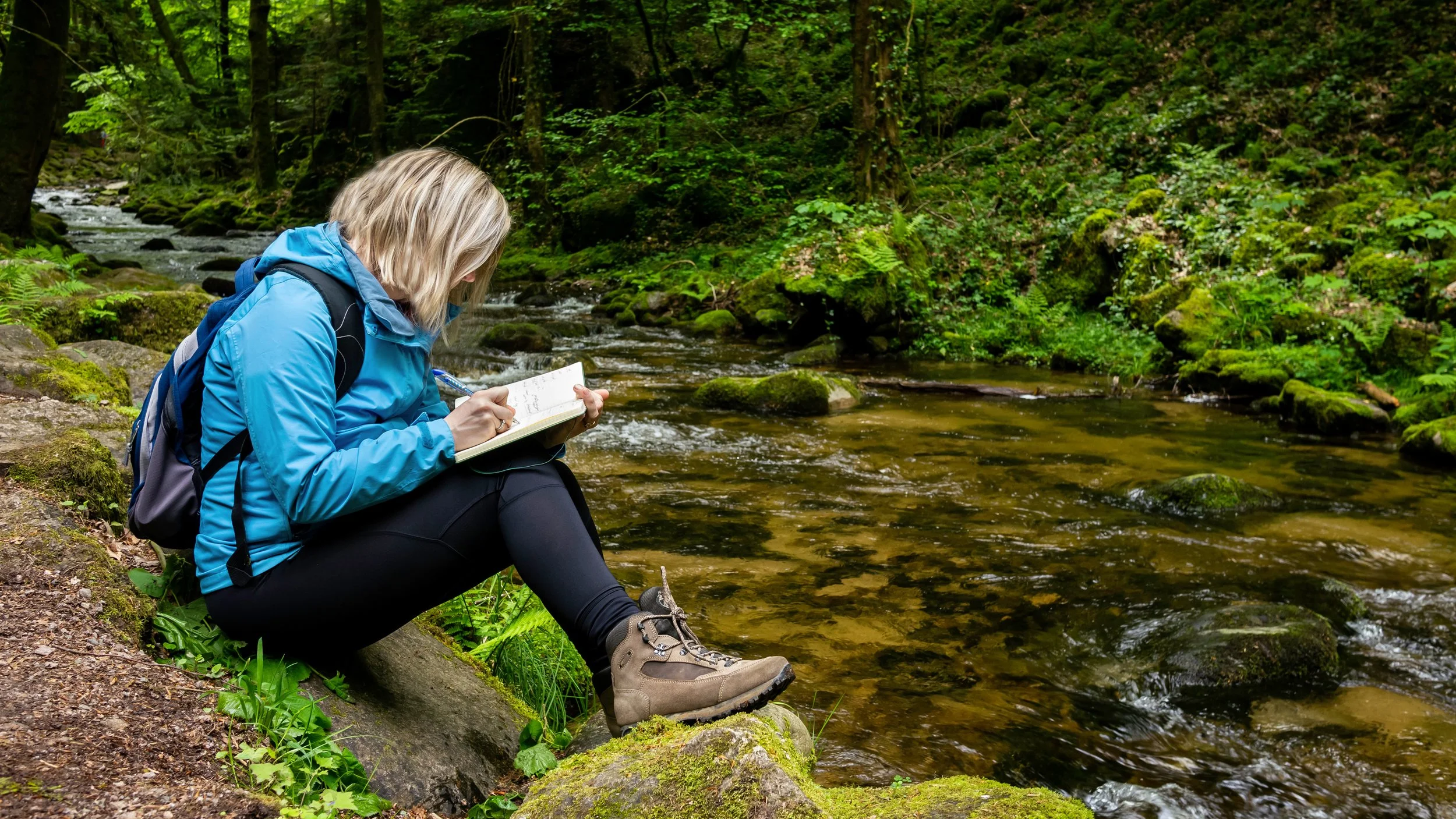 BlogHeroSpring2024_Woman reading by stream_452927583_CLRadj.jpg