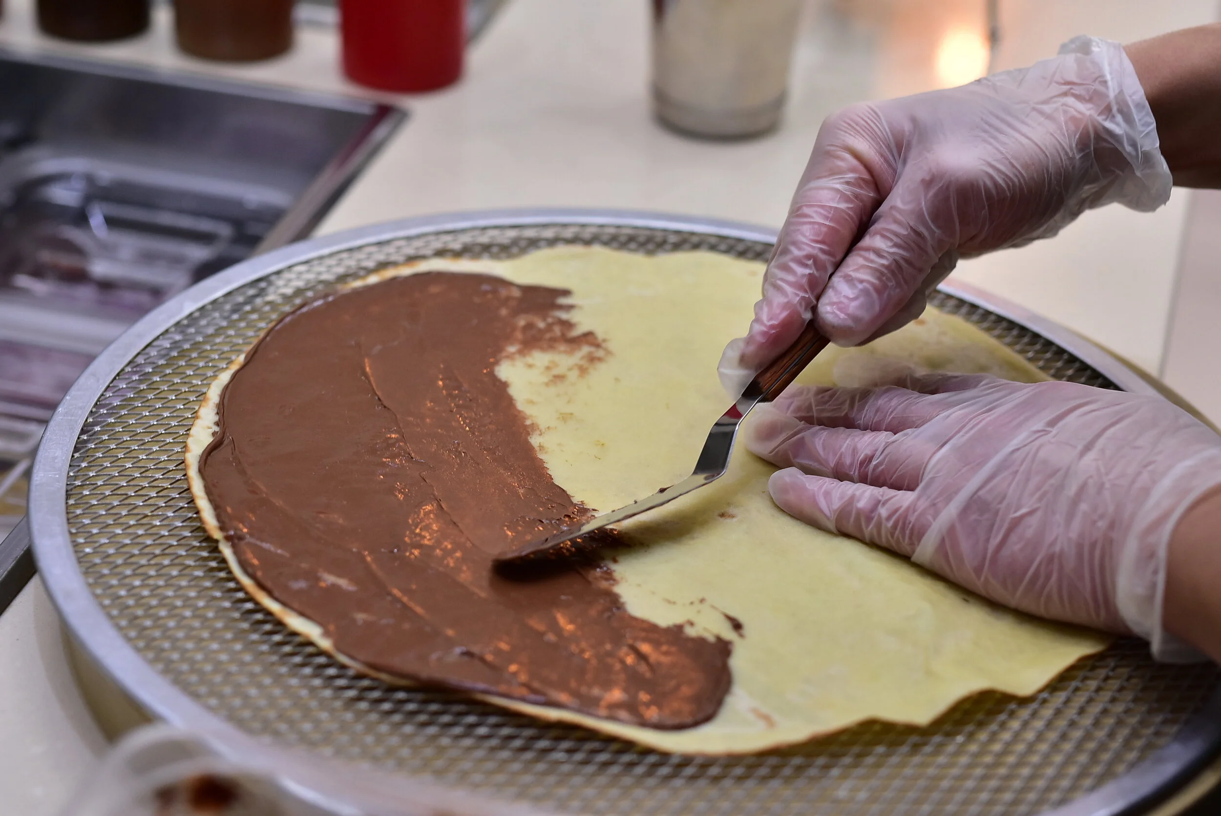 Adding chocolate sauce on crepe