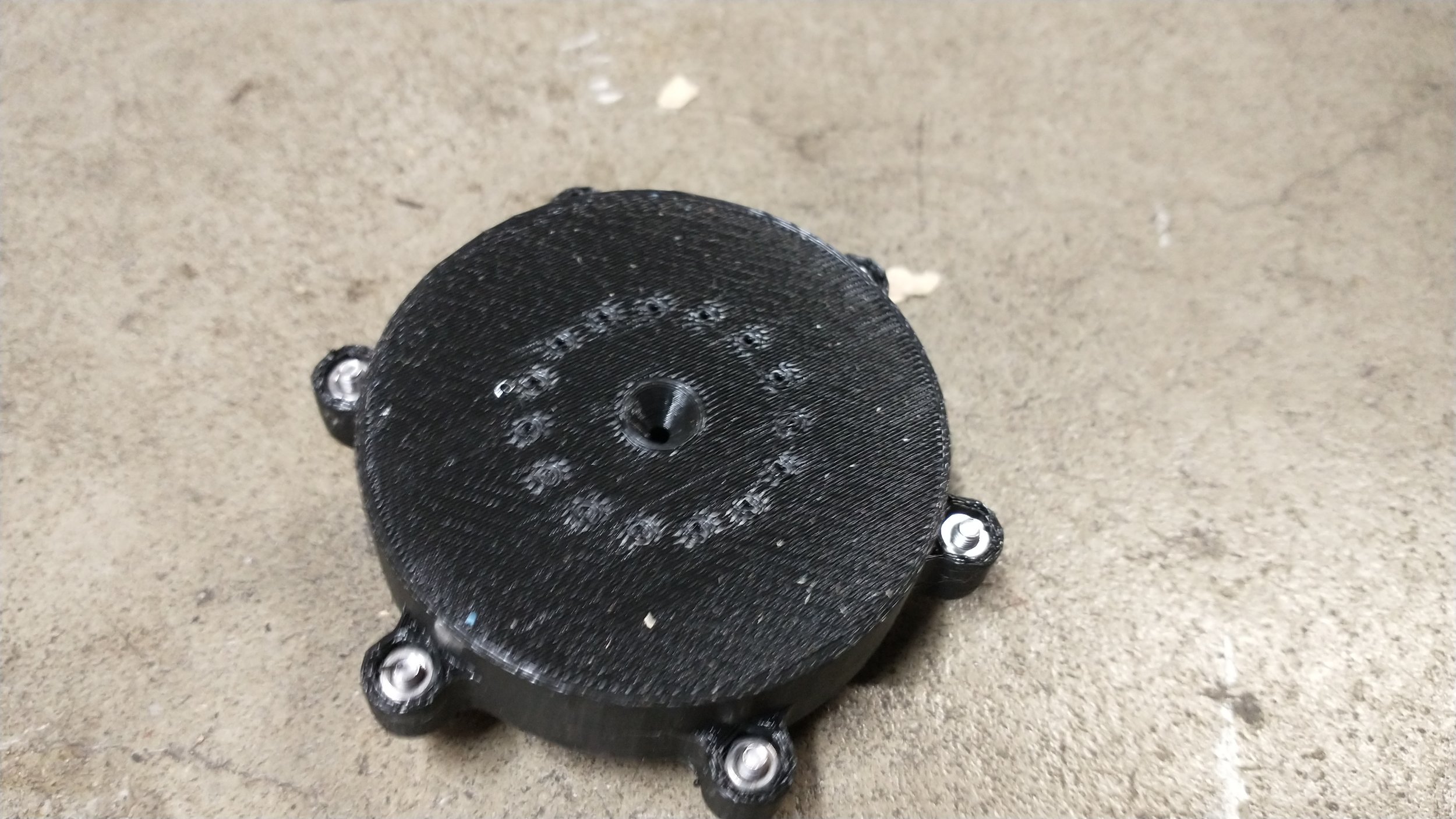 The injector from the bottom, with a spray nozzle for the water in the center and angled holes for the air around it. For more details, click the image.