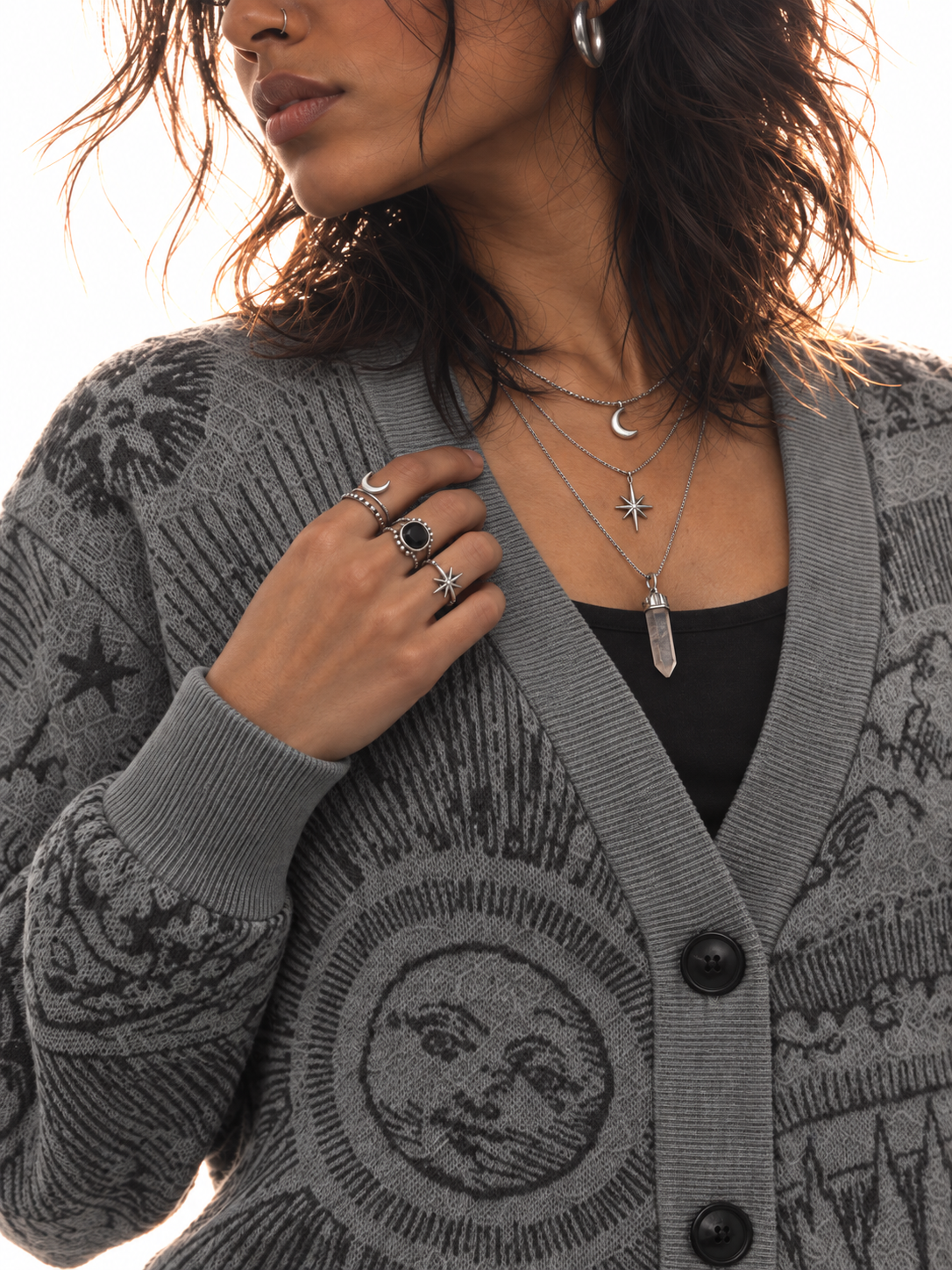 Close-up of The Anderson celestial knit with silver moon, star, and crystal necklaces
