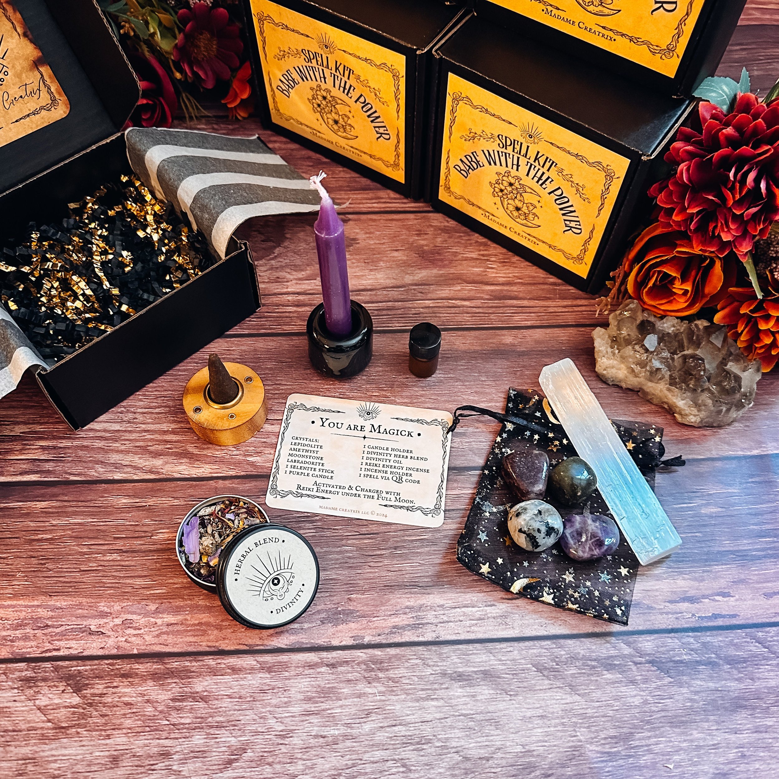 Purple chime candle standing in candle holder, incense cone standing in holder, Divinity Herbal Blend and Awakening Essential Oil for Spell Work splayed out ready for magical use.