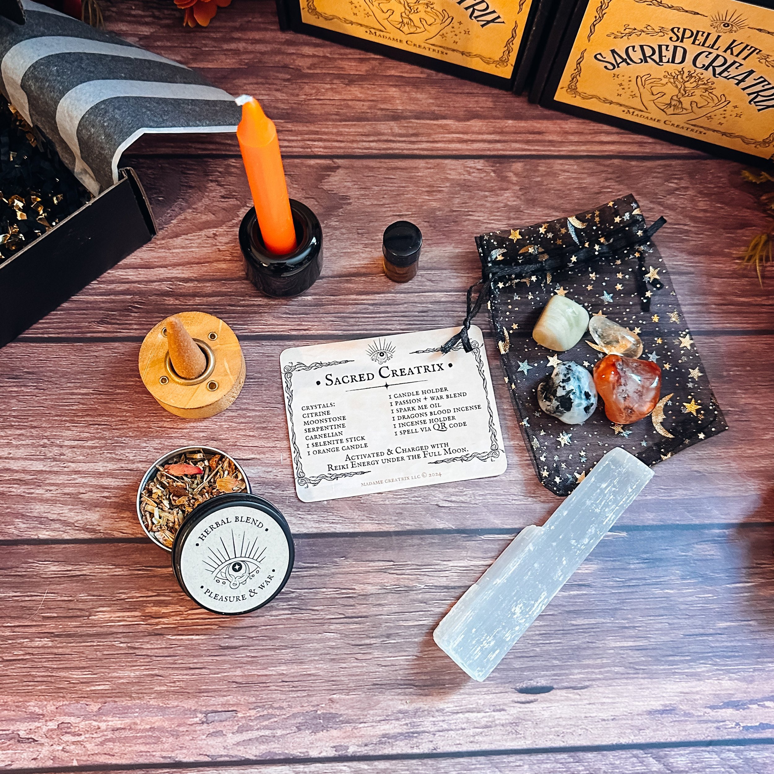 Sacred Creatrix Spell Kit: crystals, orange candle, herbal blend, oil, and incense beautifully arranged.