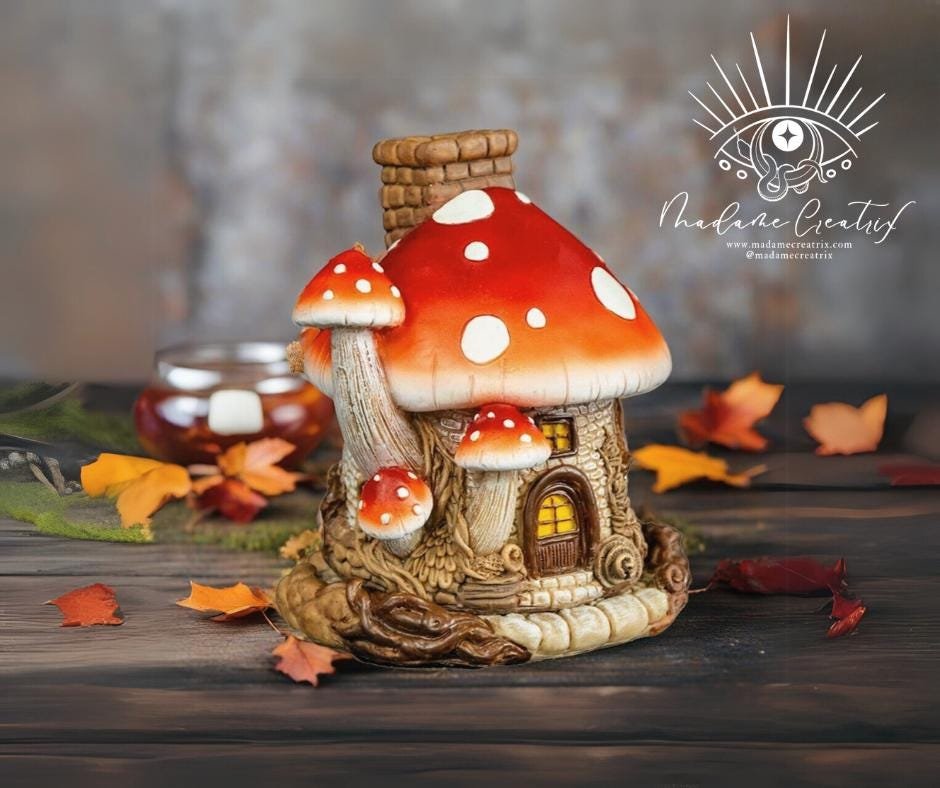 Whimsical mushroom house incense burner with colorful polyresin design, smoke emerging from the chimney.