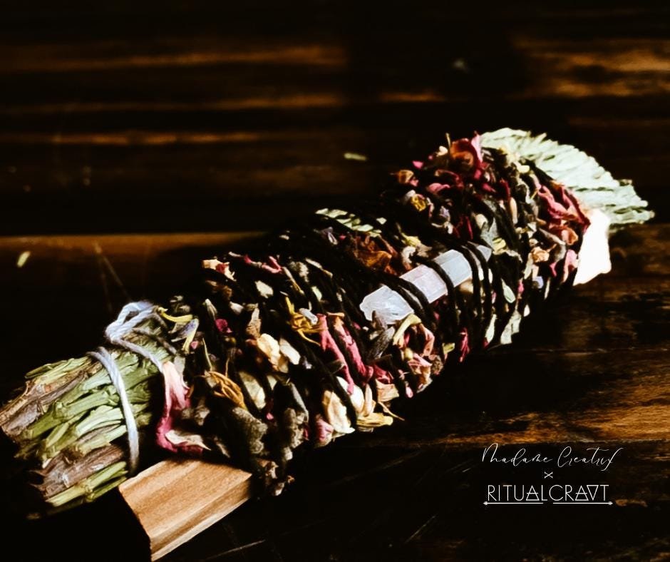 Handcrafted Cedar and Palo Santo bundle with a crystal and herbal blend, arranged on a wooden surface.