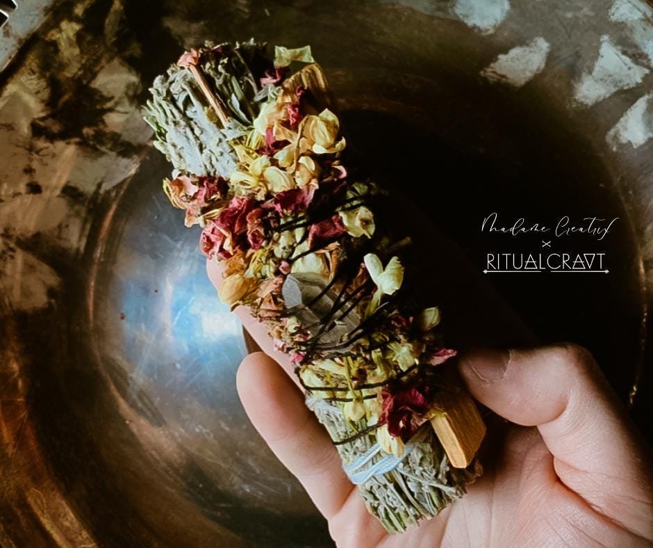 Handcrafted Mugwort and Palo Santo ritual bundle with a crystal and herb blend, arranged on a natural background.