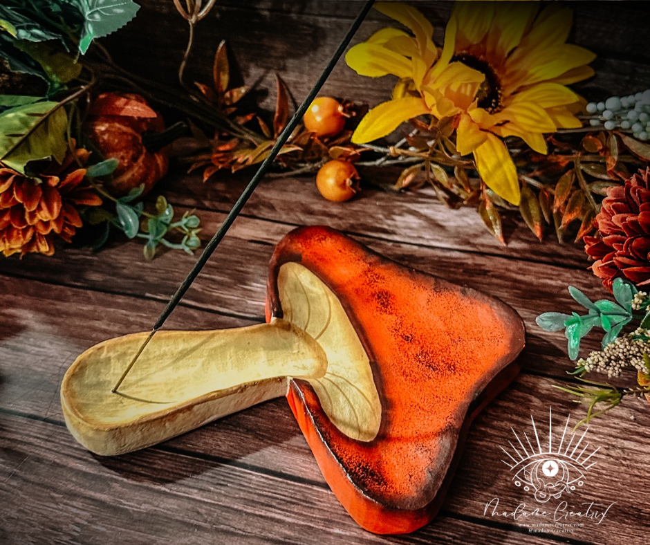 Whimsical wooden mushroom incense holder made from sustainable Albizia wood, holding incense sticks.