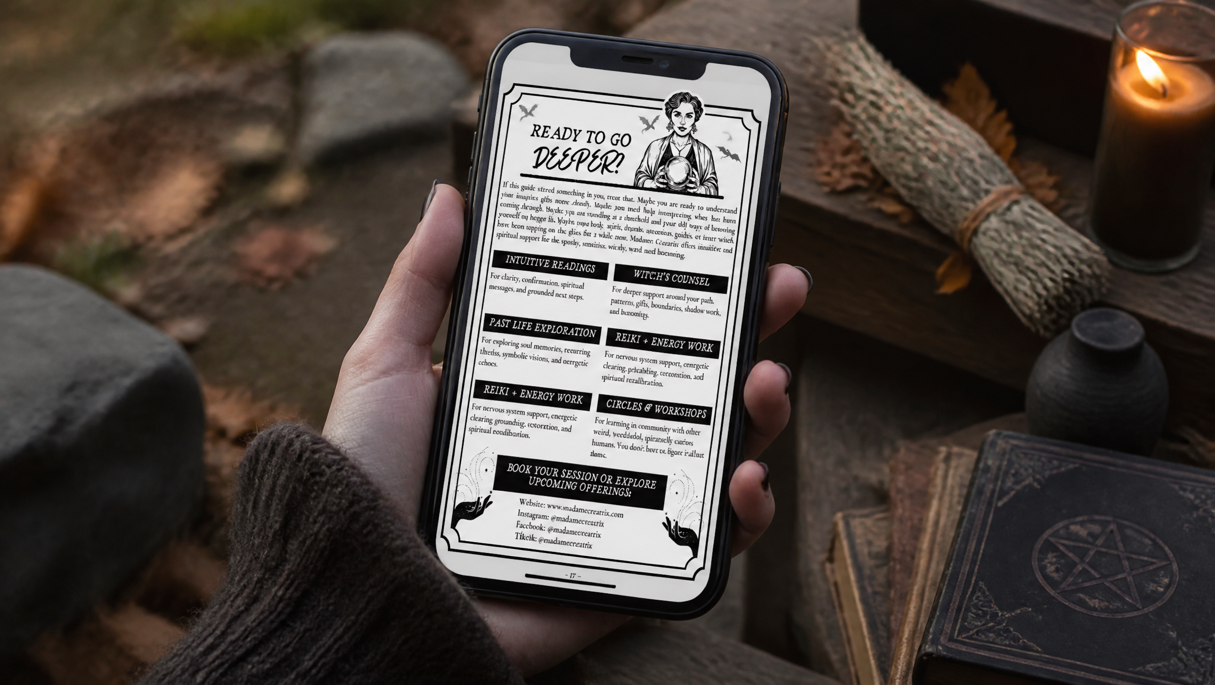 Phone displaying a page from The Wyrd One’s Guide to Intuition beside a candle, dried leaves, and a dark occult-style book.