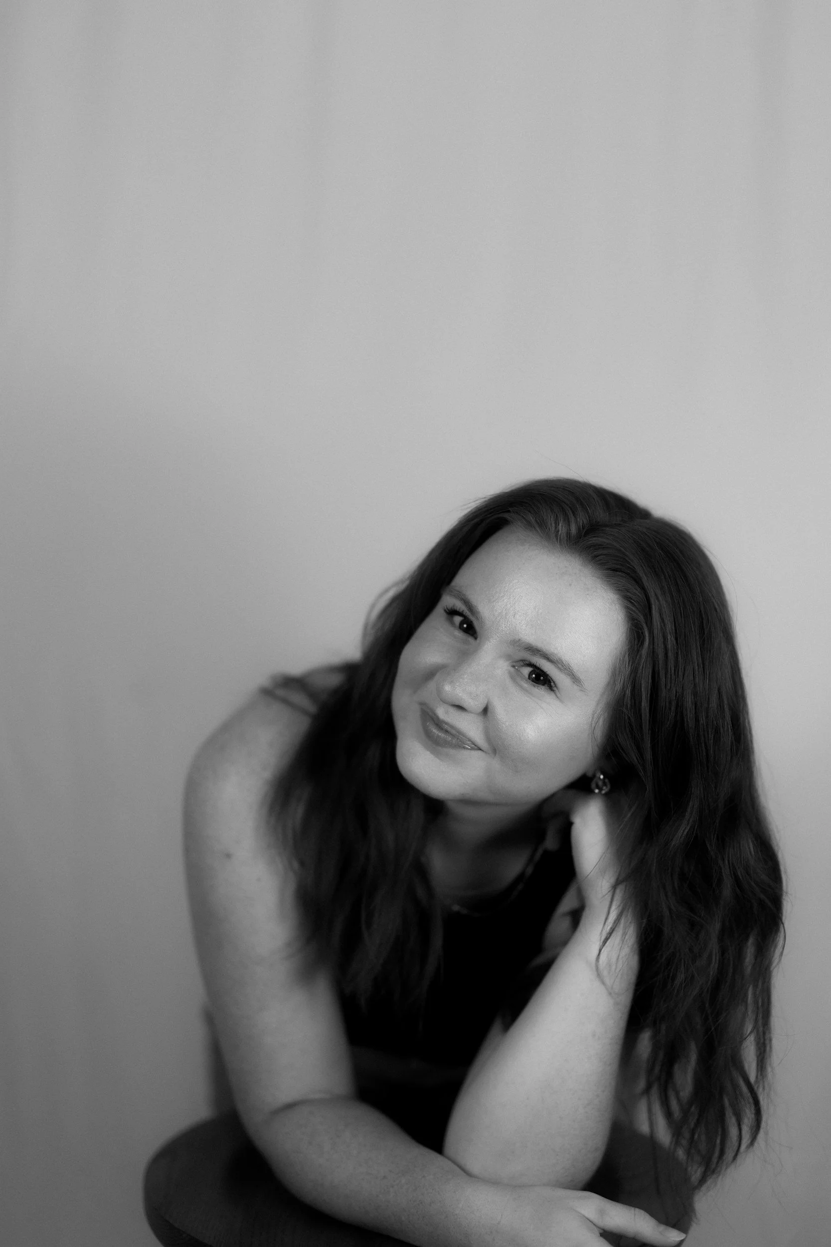 A black and white portrait of a woman smiling - therapy for self-esteem