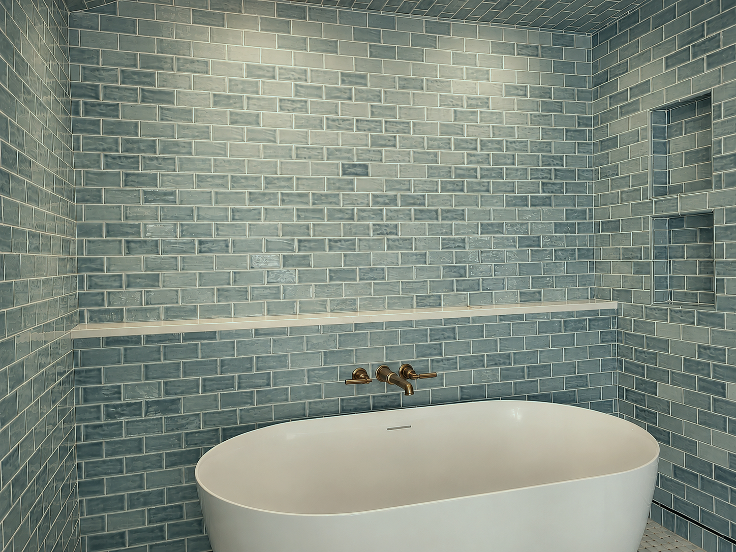 A wall mounted tub filler underneath a room-wide marble shelf, perfect for decorations and accessories.