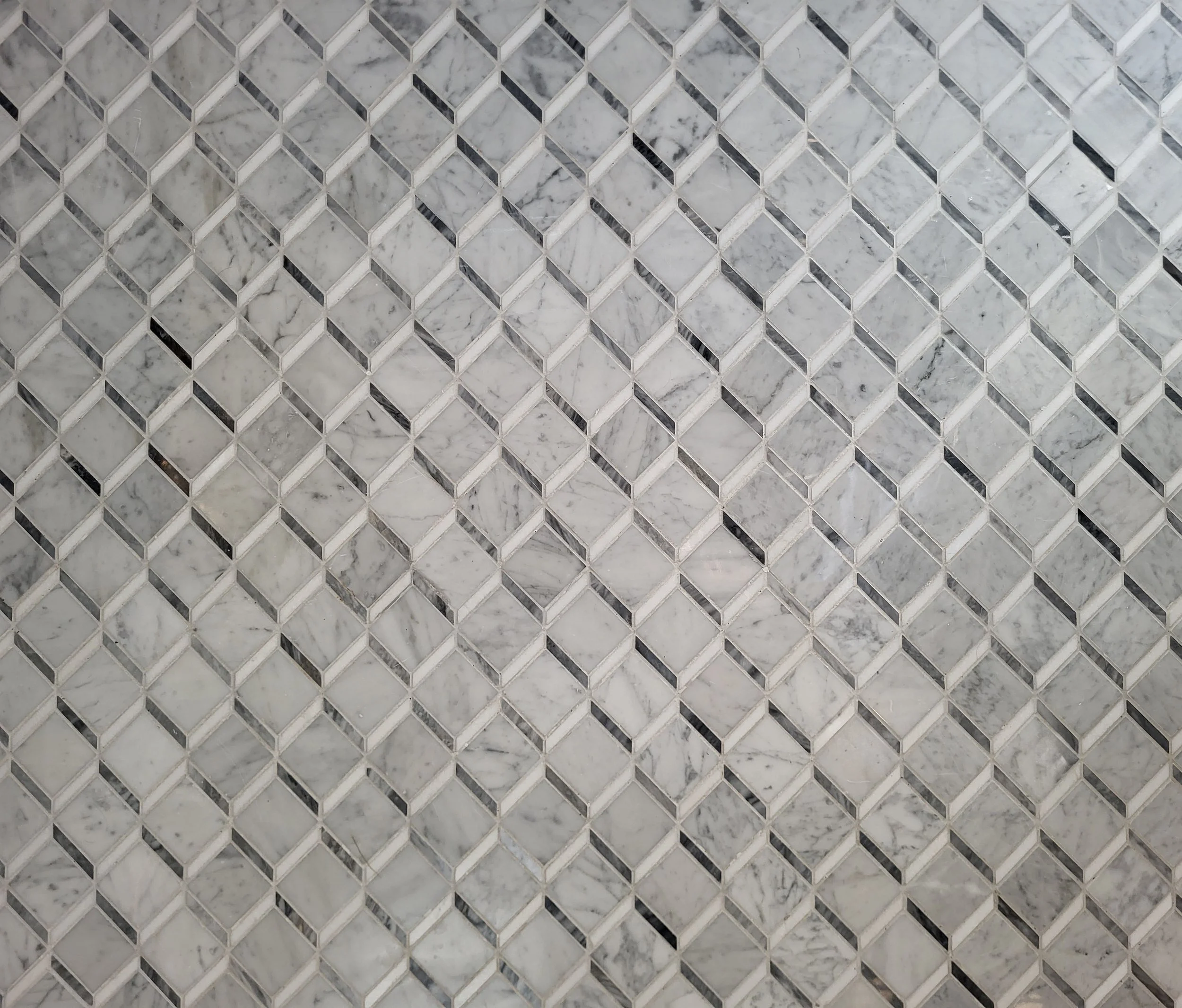 Marble mosaic tile with curbless shower entry.