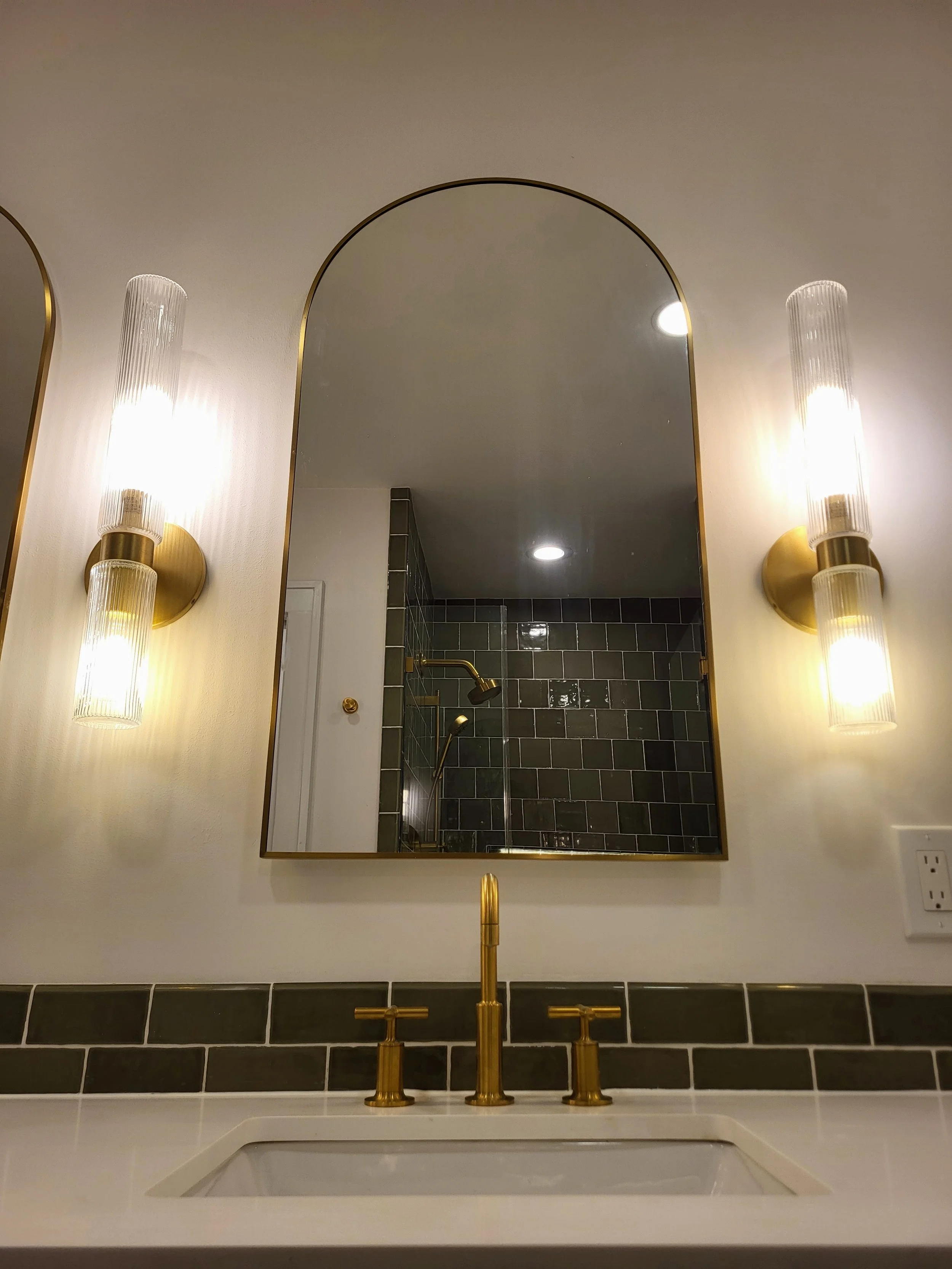 Arched medicine cabinet with sconces on both sides.
