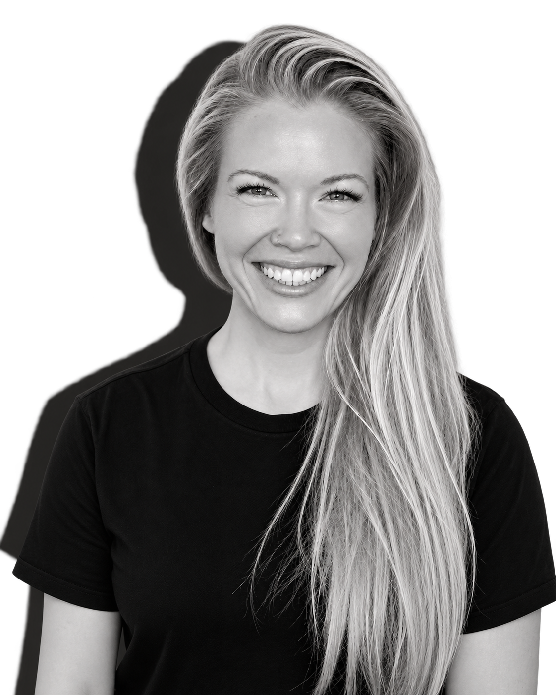 Black and white portrait of a smiling woman with long blonde hair wearing a black t-shirt.