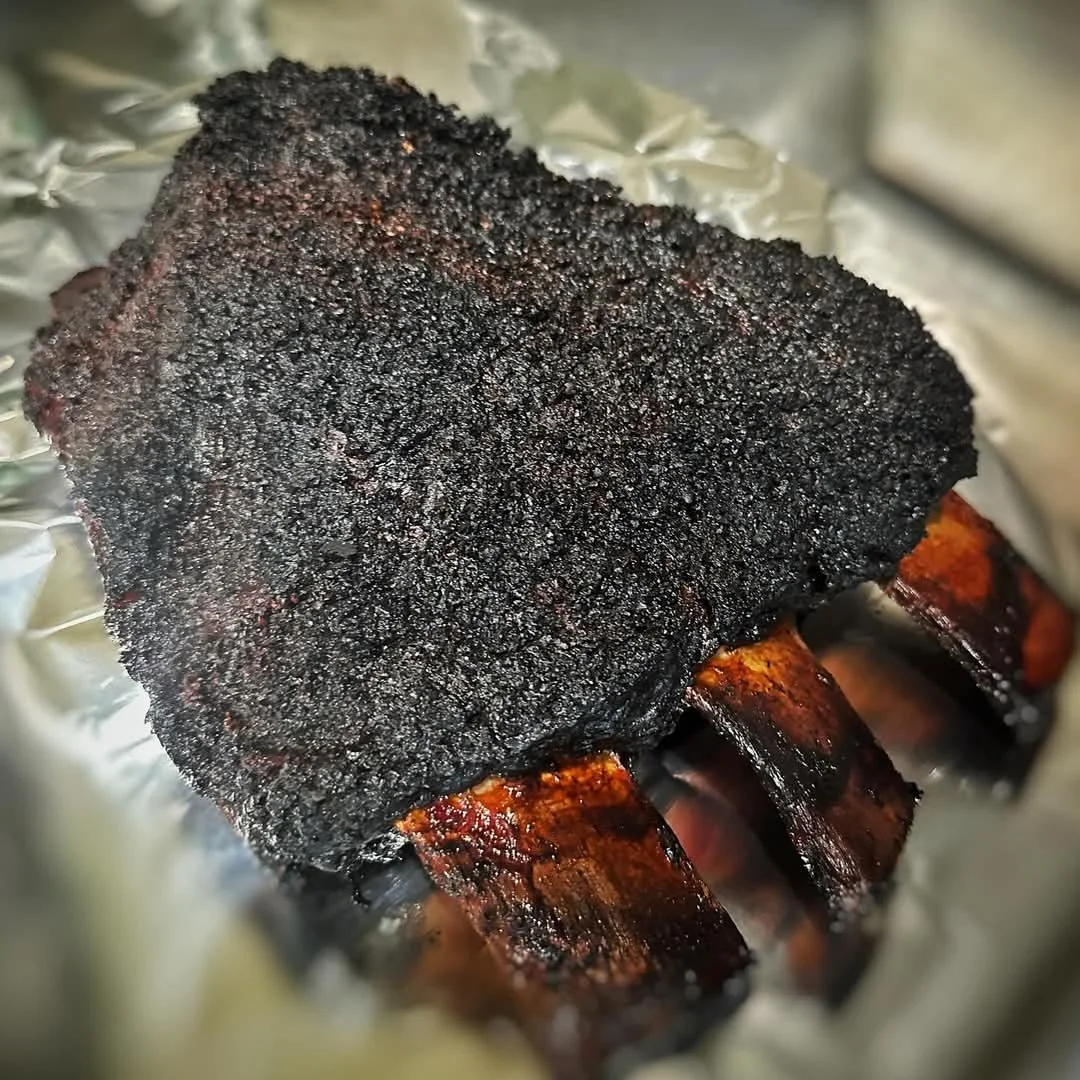Texas-style slow-smoked beef short ribs with a rich dark BBQ bark, prepared at Moo Moo Smokehouse & Grill in Auckland.