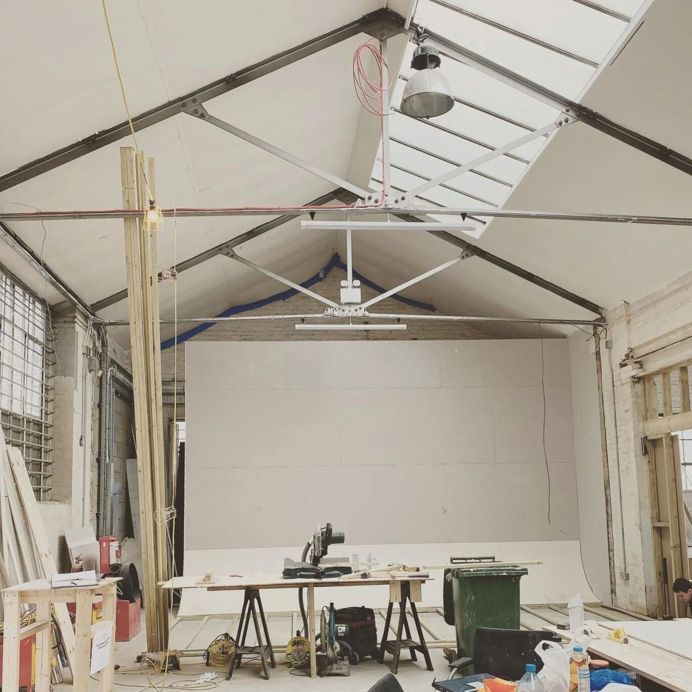 Photography suites, for all their white backdrops and even lighting, take a surprising amount of coordination! This was the first project we did with a coved screen, custom built with equipment storage behind, for @weareqube in Acton. Here we are, ei