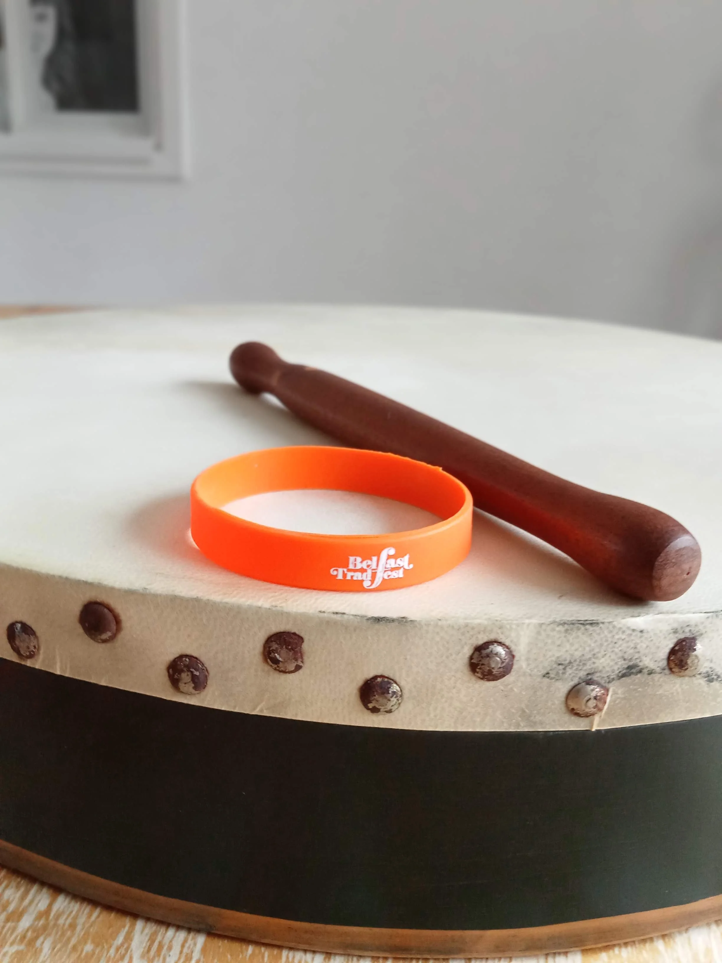 Bodhrán and tipper with a Belfast Tradfest wristband