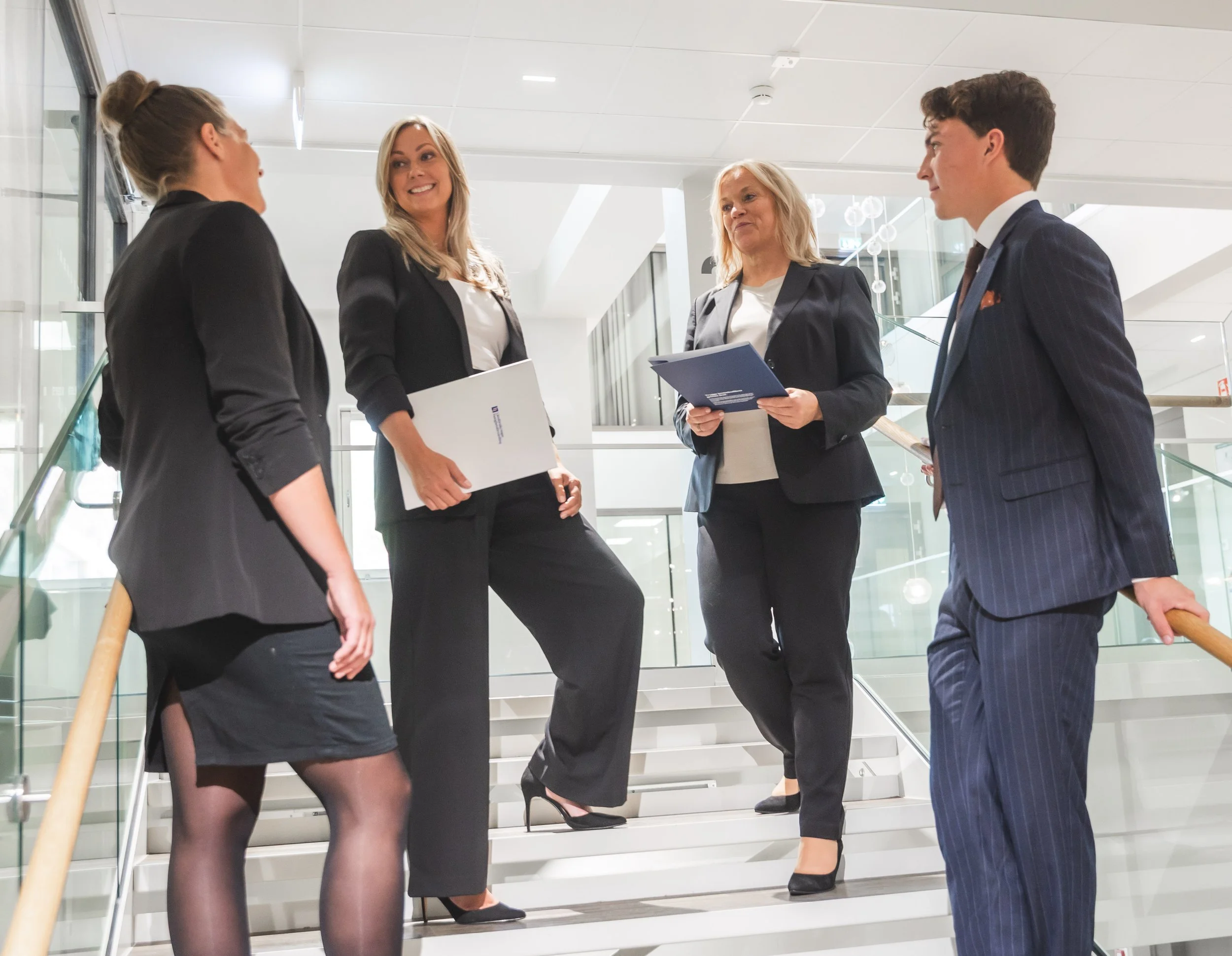 Business colleagues having a discussion on stairs in modern office building.