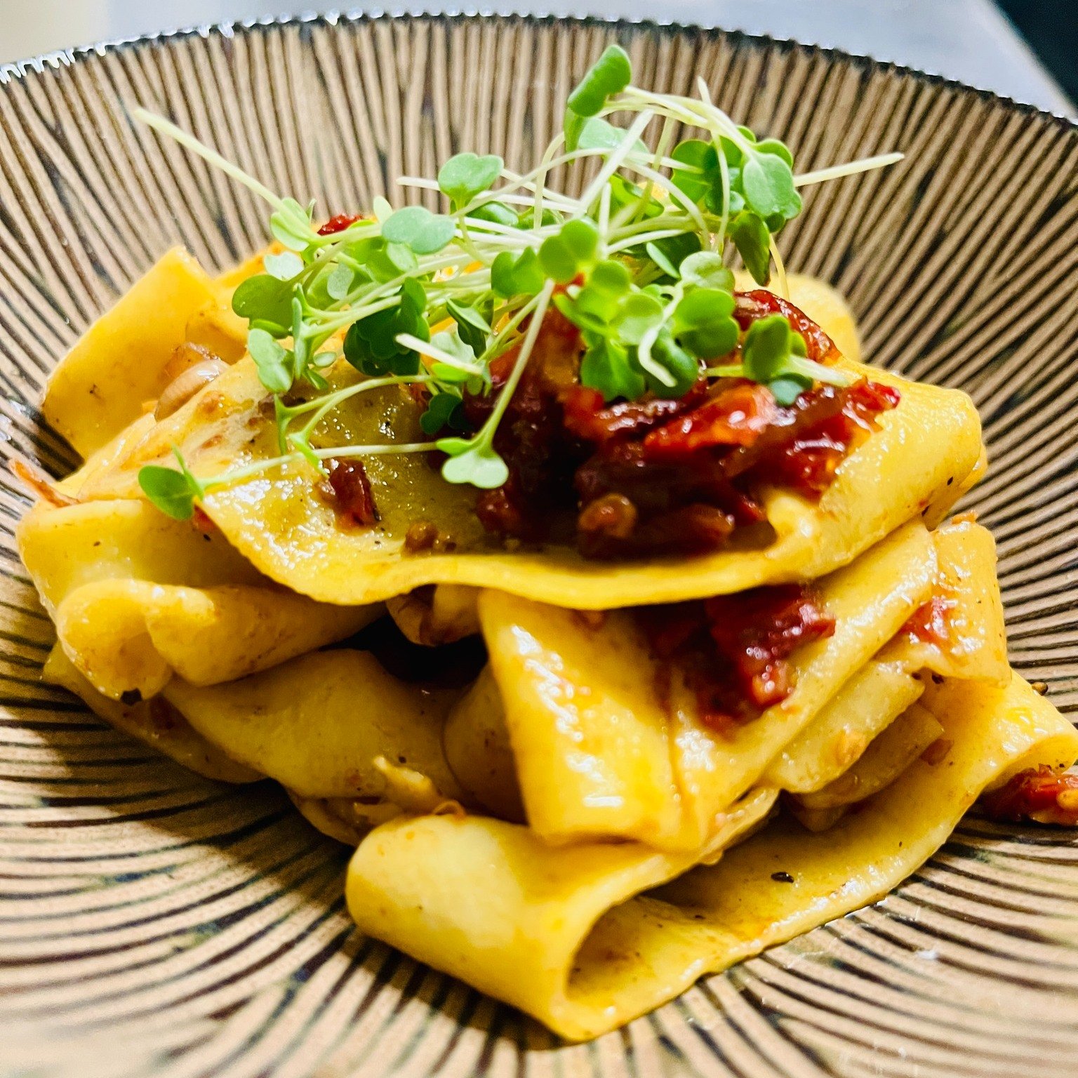 Our hand‑rolled pappardelle return this weekend, and they are every bit as decadent as you remember.

Wide, silky ribbons of fresh handmade pasta catch a sauce built on slow‑sweated shallots, sun‑dried tomatoes and the deep, savory sweetness of black