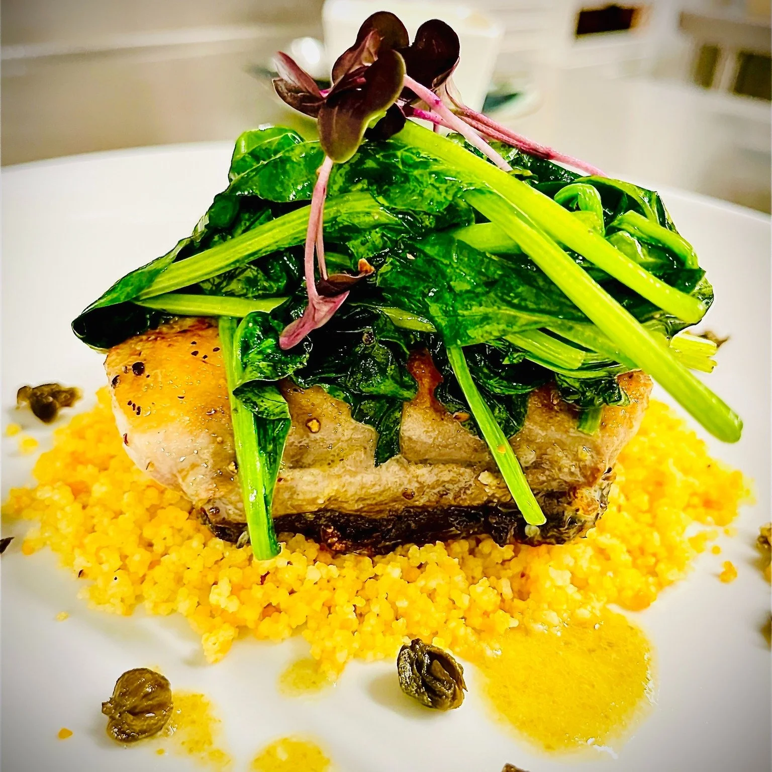 Fresh mahi fillet from Sam Rust Seafood, cooked just right &mdash; crispy skin giving way to tender, flaky flesh. Finished with a tangy lemon-caper-garlic beurre blanc, fried capers for crunch, saut&eacute;ed spinach for balance and fluffy couscous t