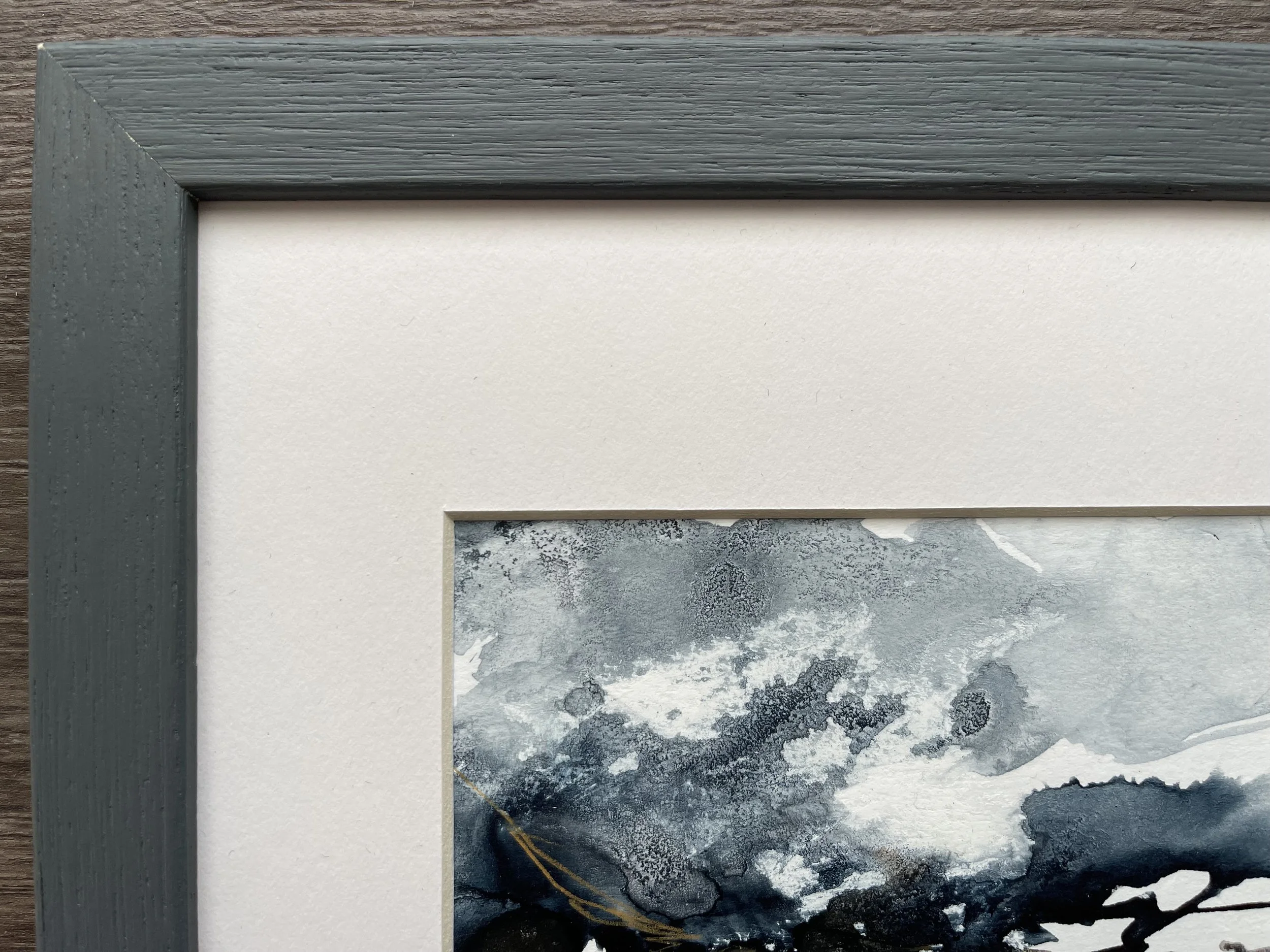 Close up of the frame and mount of this abstract seascape painting in shades of blue and sepia