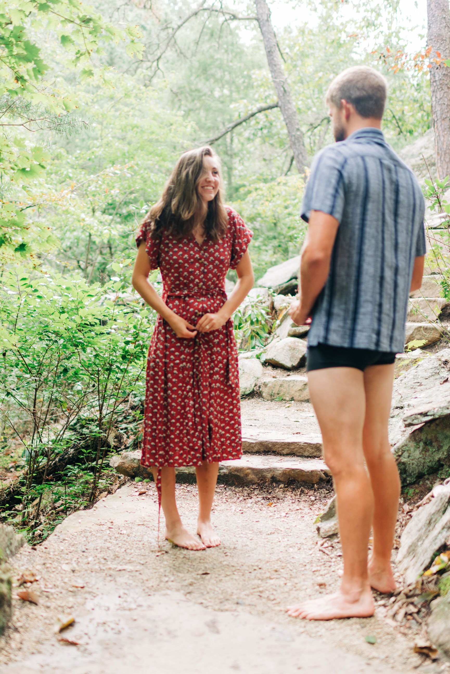  Couple getting dressed together outside to take engagement photos 