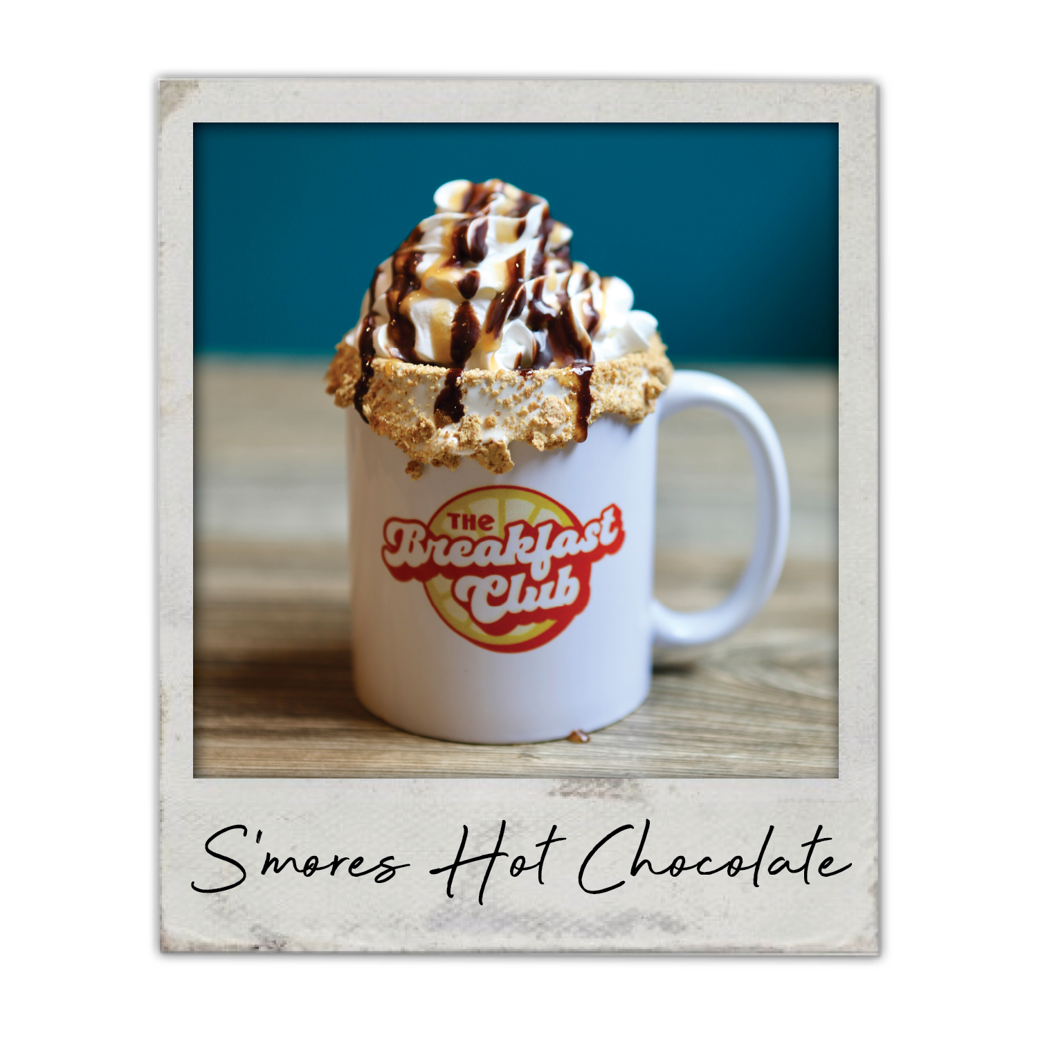 S’mores Hot Chocolate | The Breakfast Club USA: A hot chocolate topped with whipped cream, chocolate drizzle, and s’mores-style garnish.