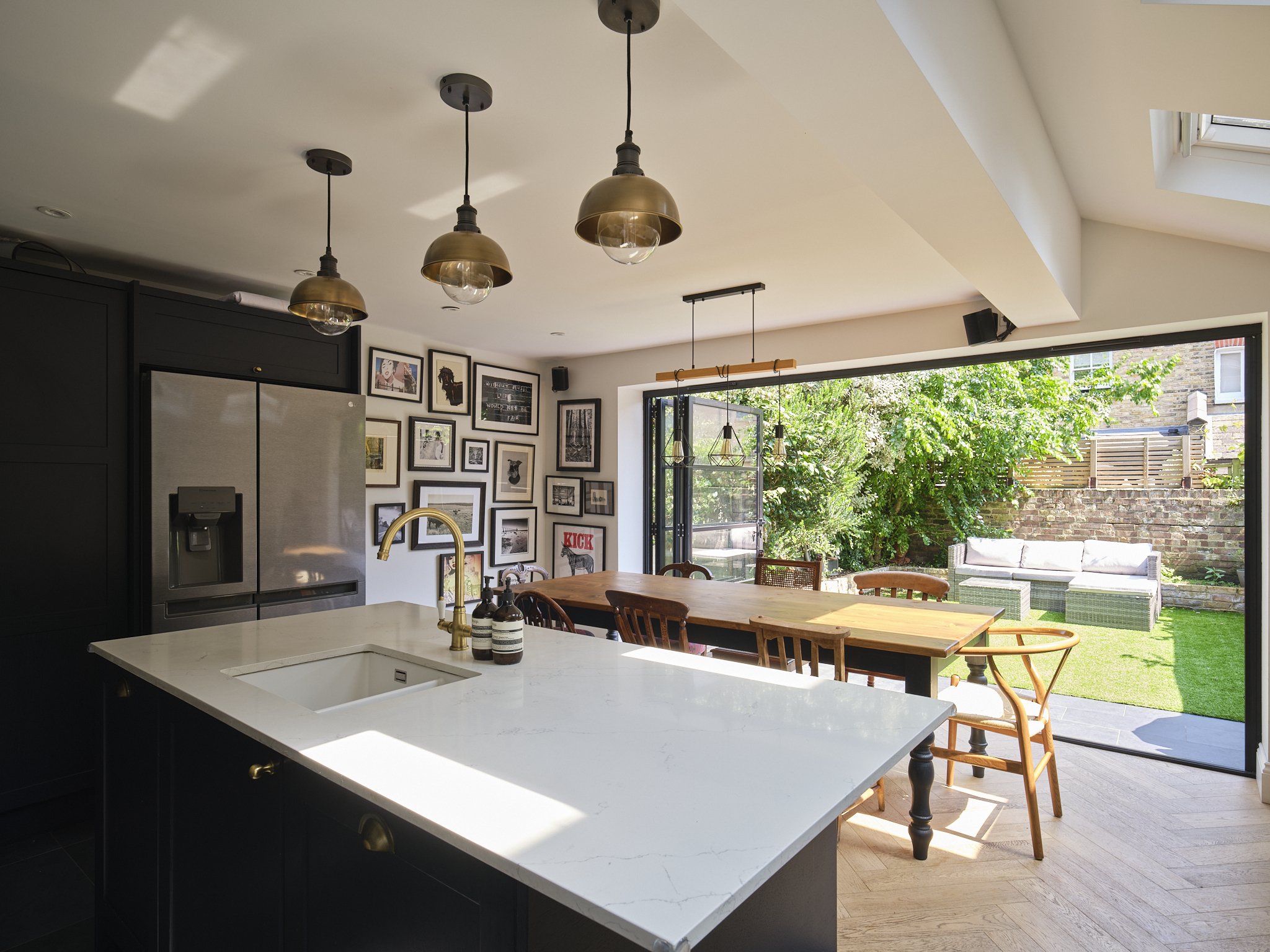 Kitchen deign with dark cabinetry and brass chandeliers