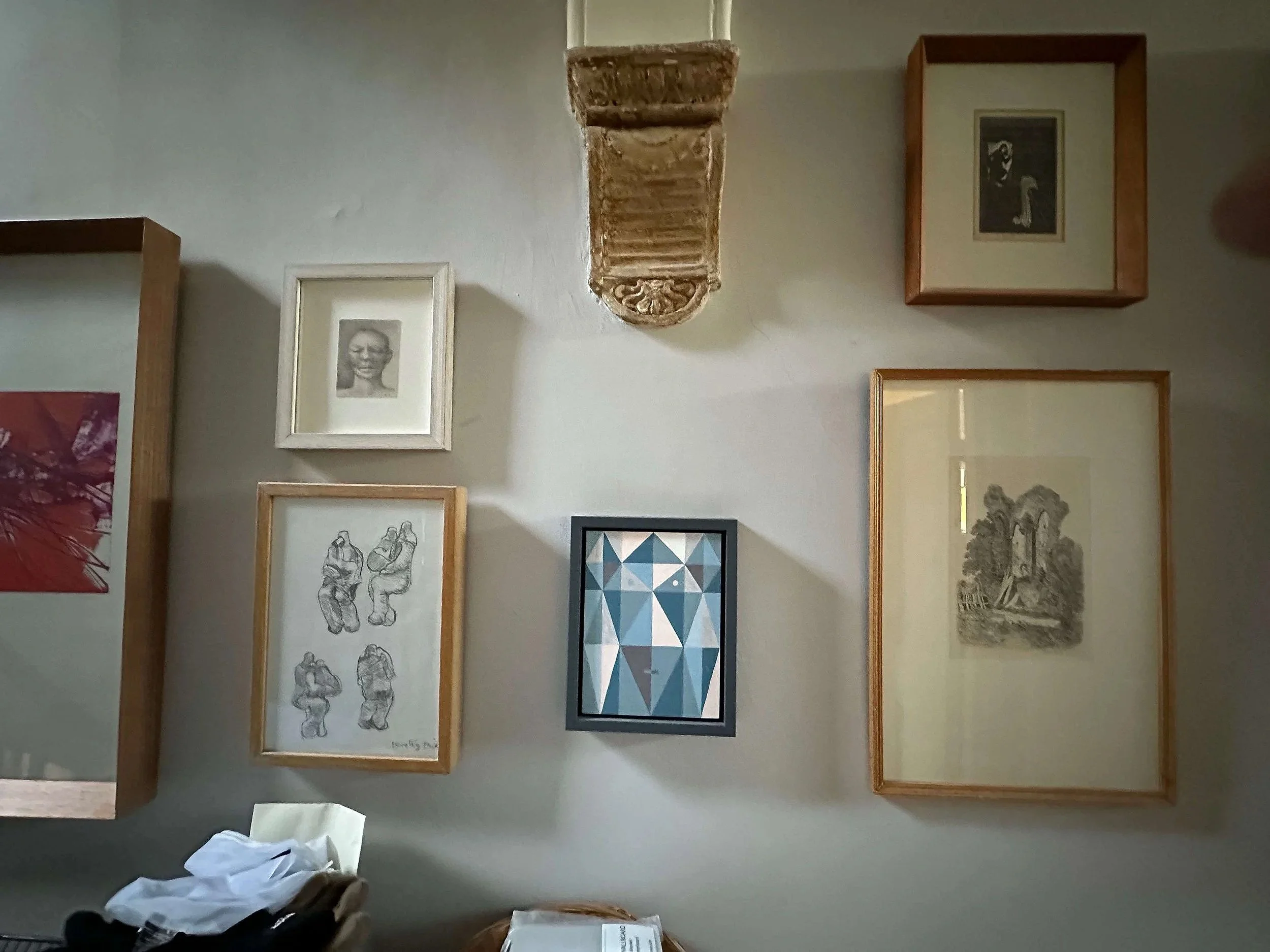 Small framed artworks showing sculptural figures and abstract compositions
