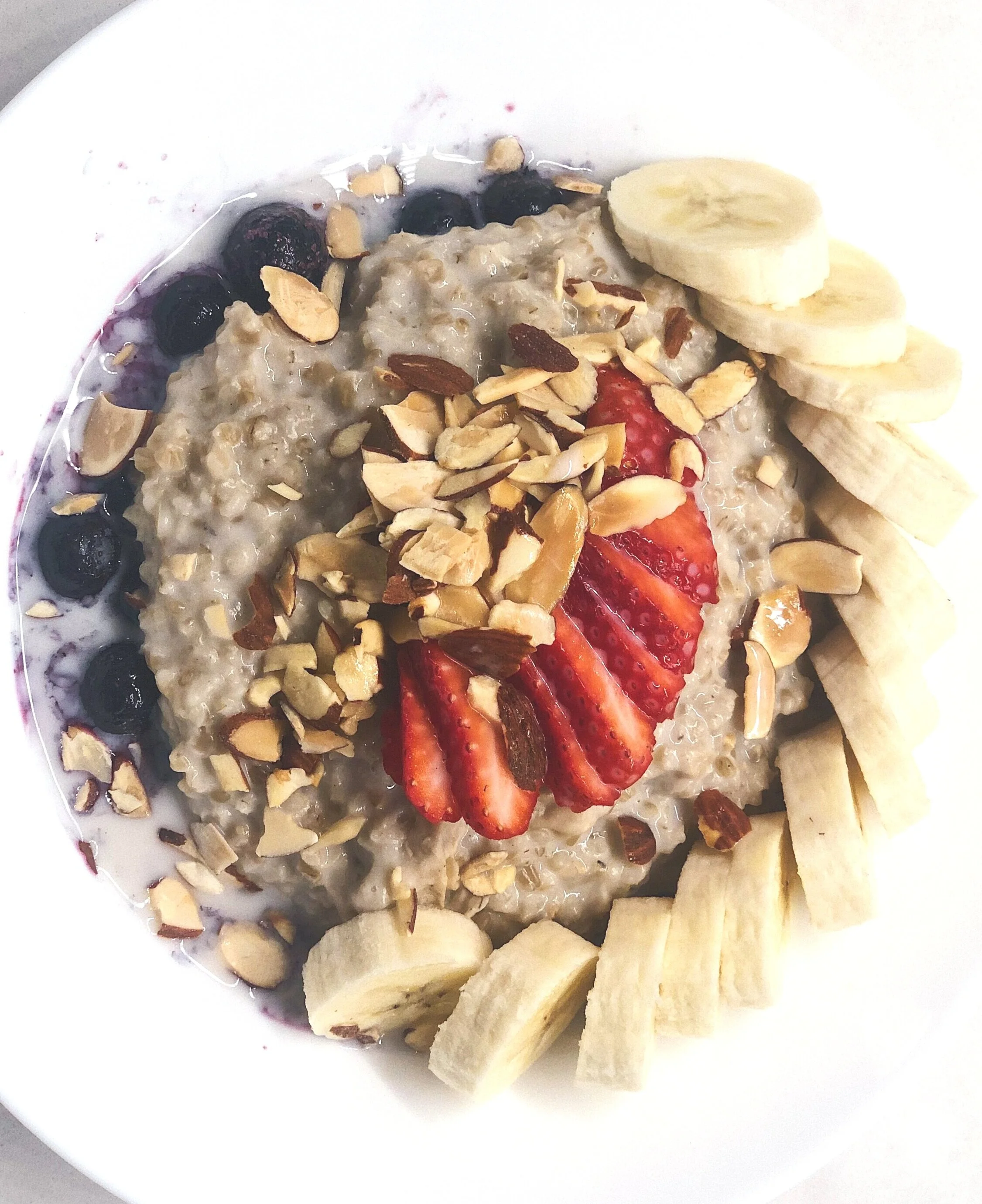 Steel-cut oats, pictured with chopped almonds, fresh strawberries, and bananas