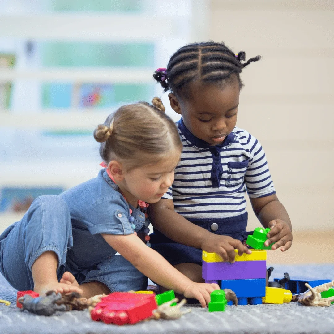 Toddlers playing together with blocks.