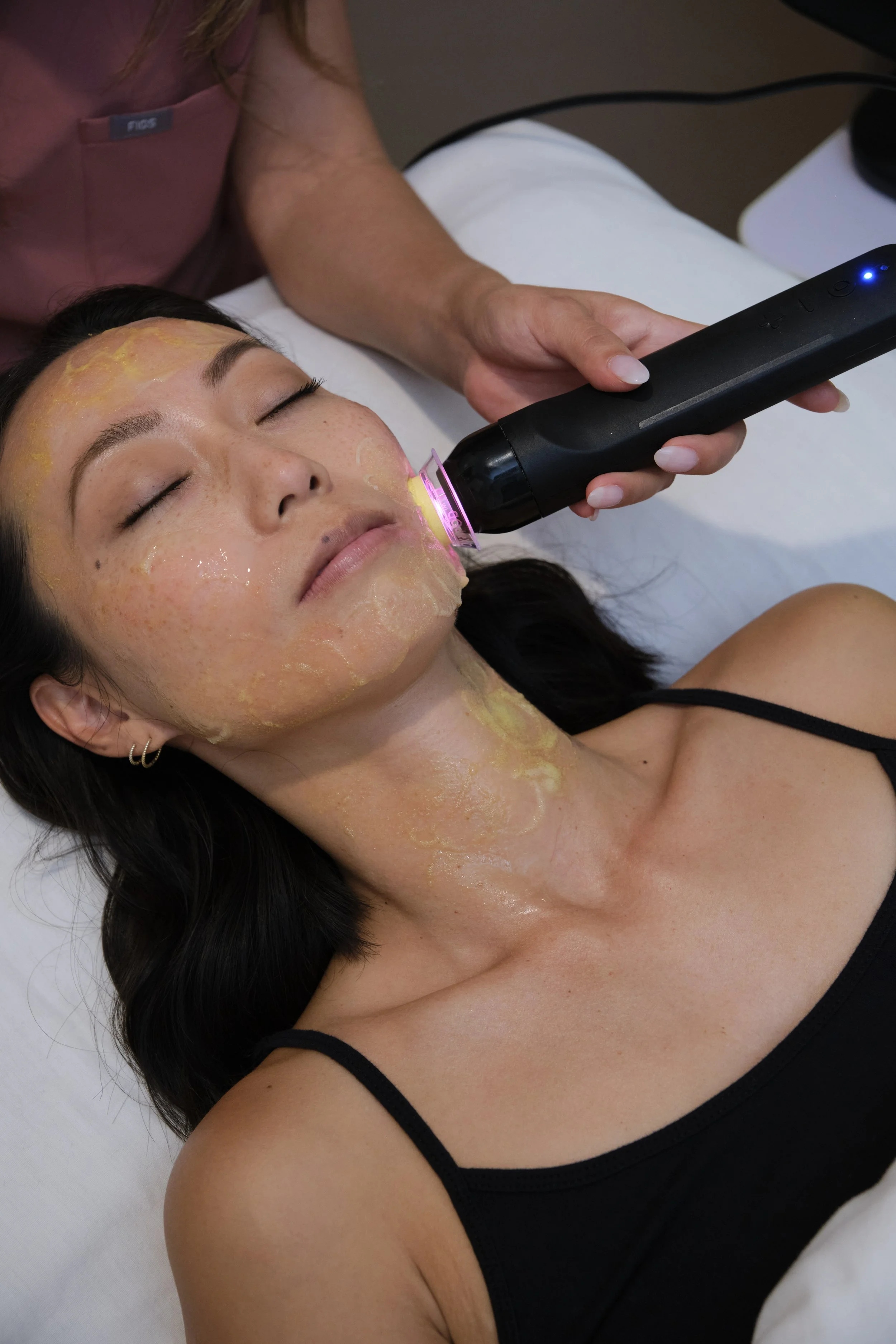 Licensed Esthetician performing Glo2Facial service on woman