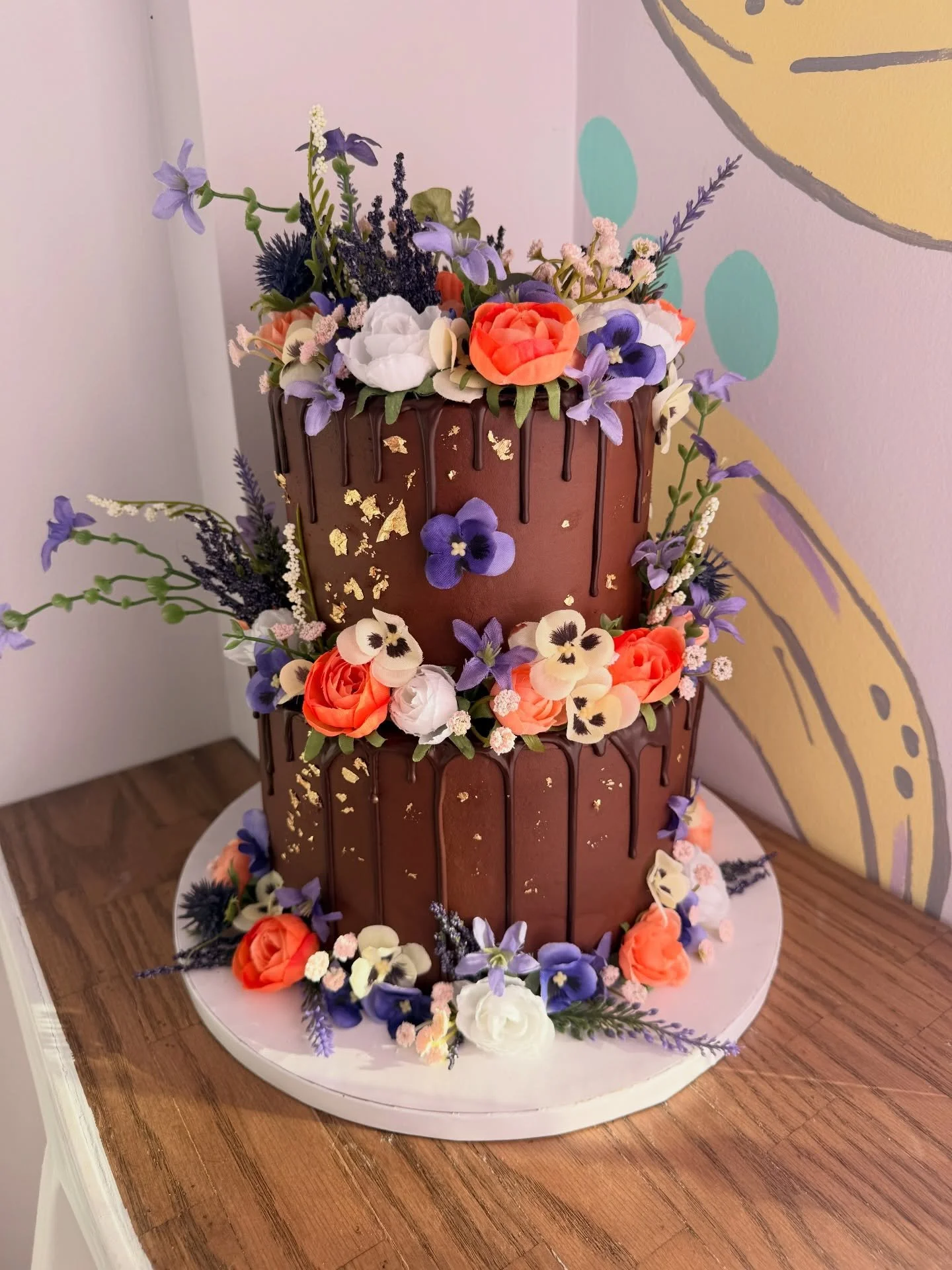 From delicate garden blooms to bold floral drama ✨🌸🍫

Two completely different cake styles&hellip; both equally stunning in their own way. 🪻🌷💐🌸🌼

One soft and whimsical with hand-piped florals, the other rich and dramatic with chocolate drips,