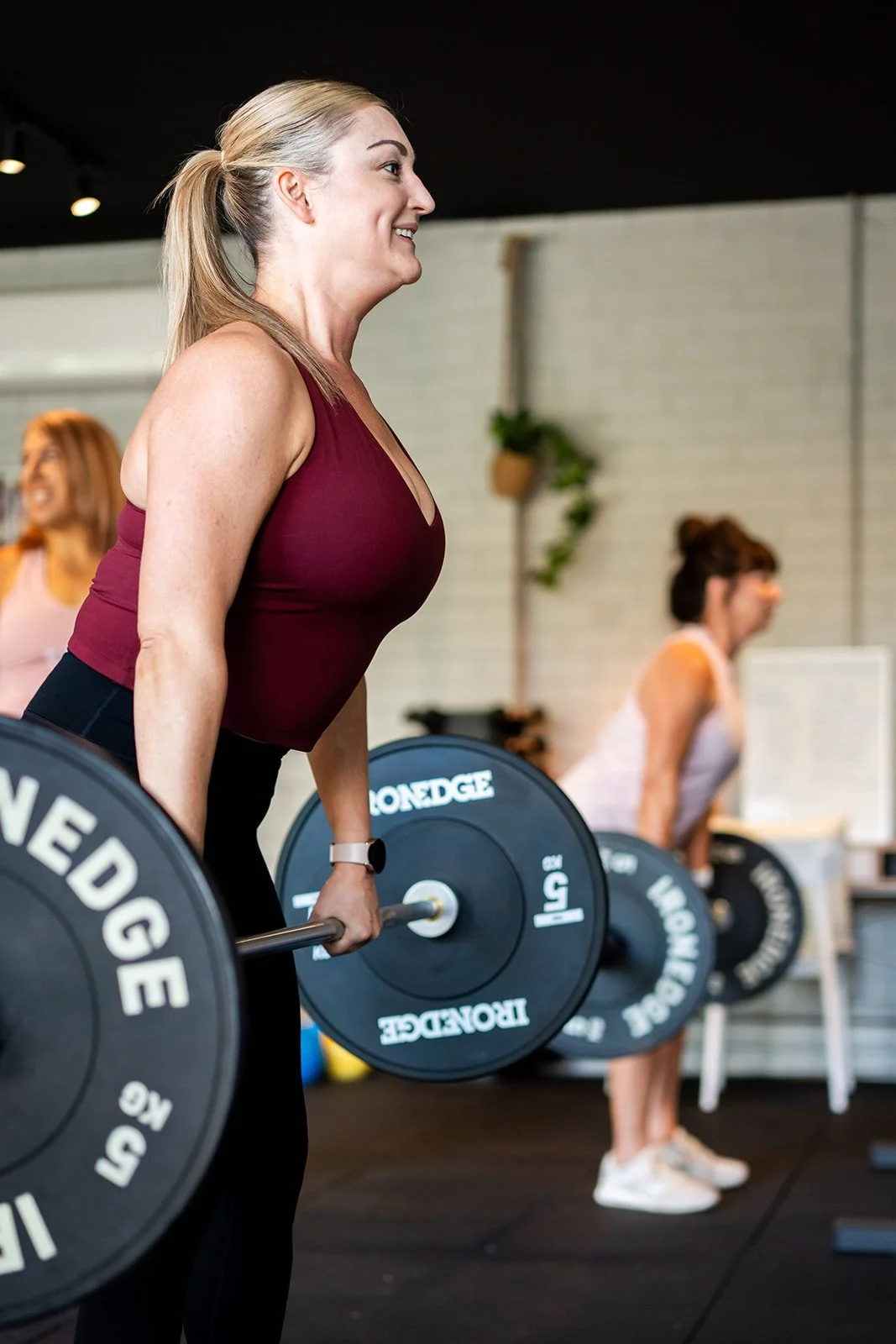 Graphic designer Leysa Flores sitting on a stool with a book open in her lap – image captured by Sunday Muse Studio