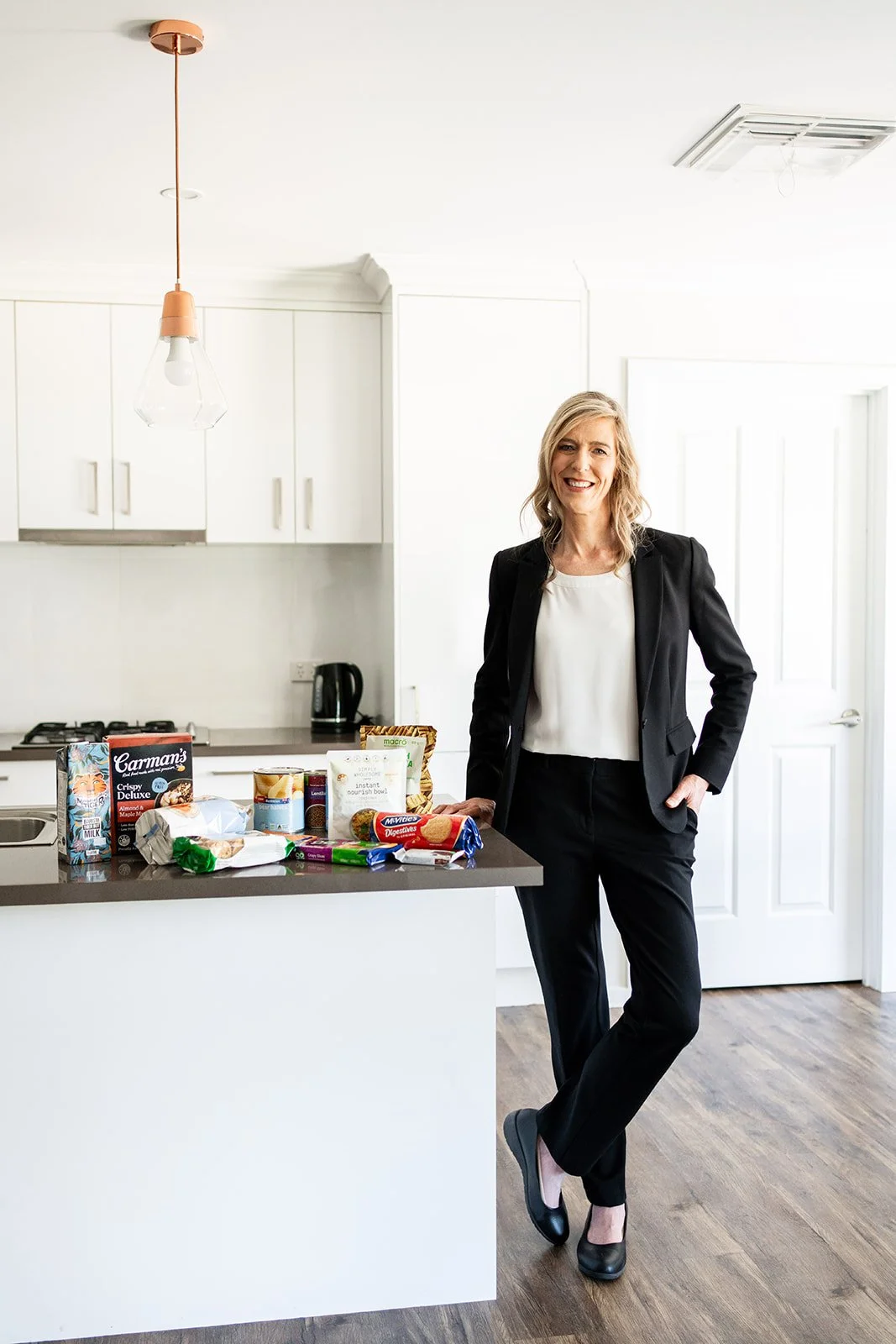 Massage therapist, Tarren stands in amongst the Australian bush, smiling joyfully  – image captured by Sunday Muse Studio