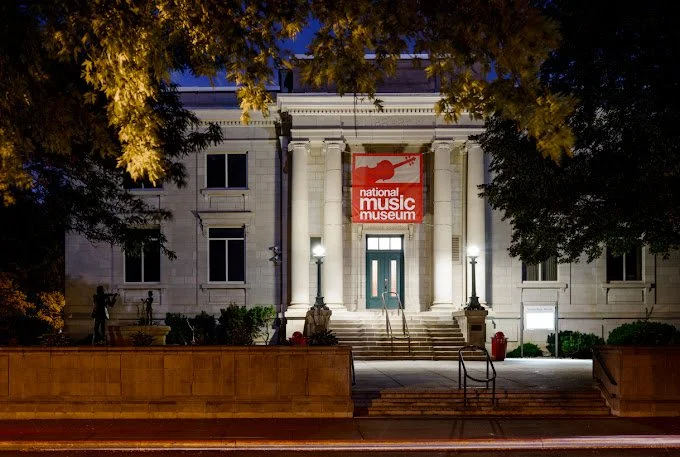 Image of white building with large columns and a red "national music museum" hanging above door.