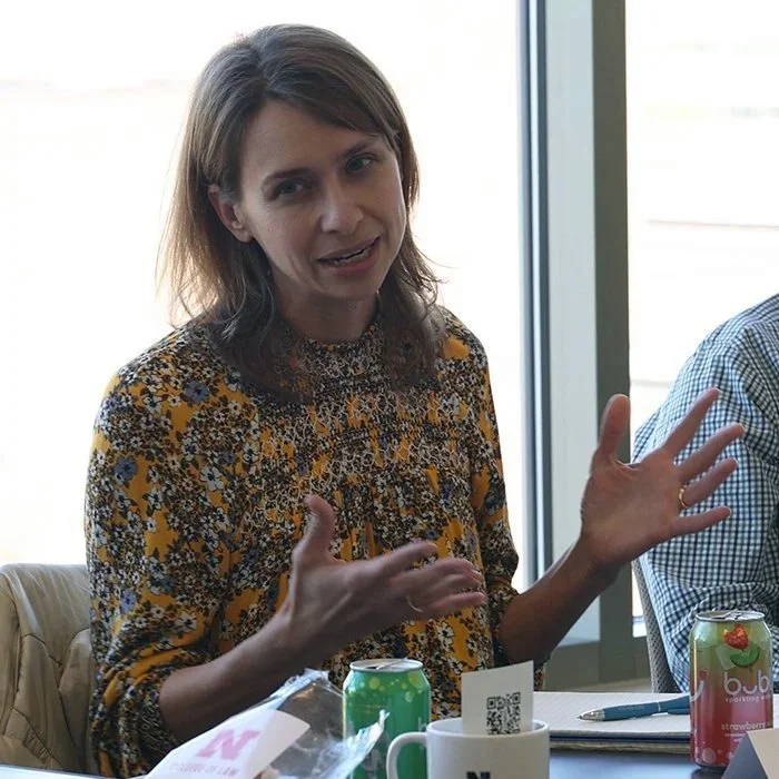 Loka Ashwood speaks while seated at a workshop table.