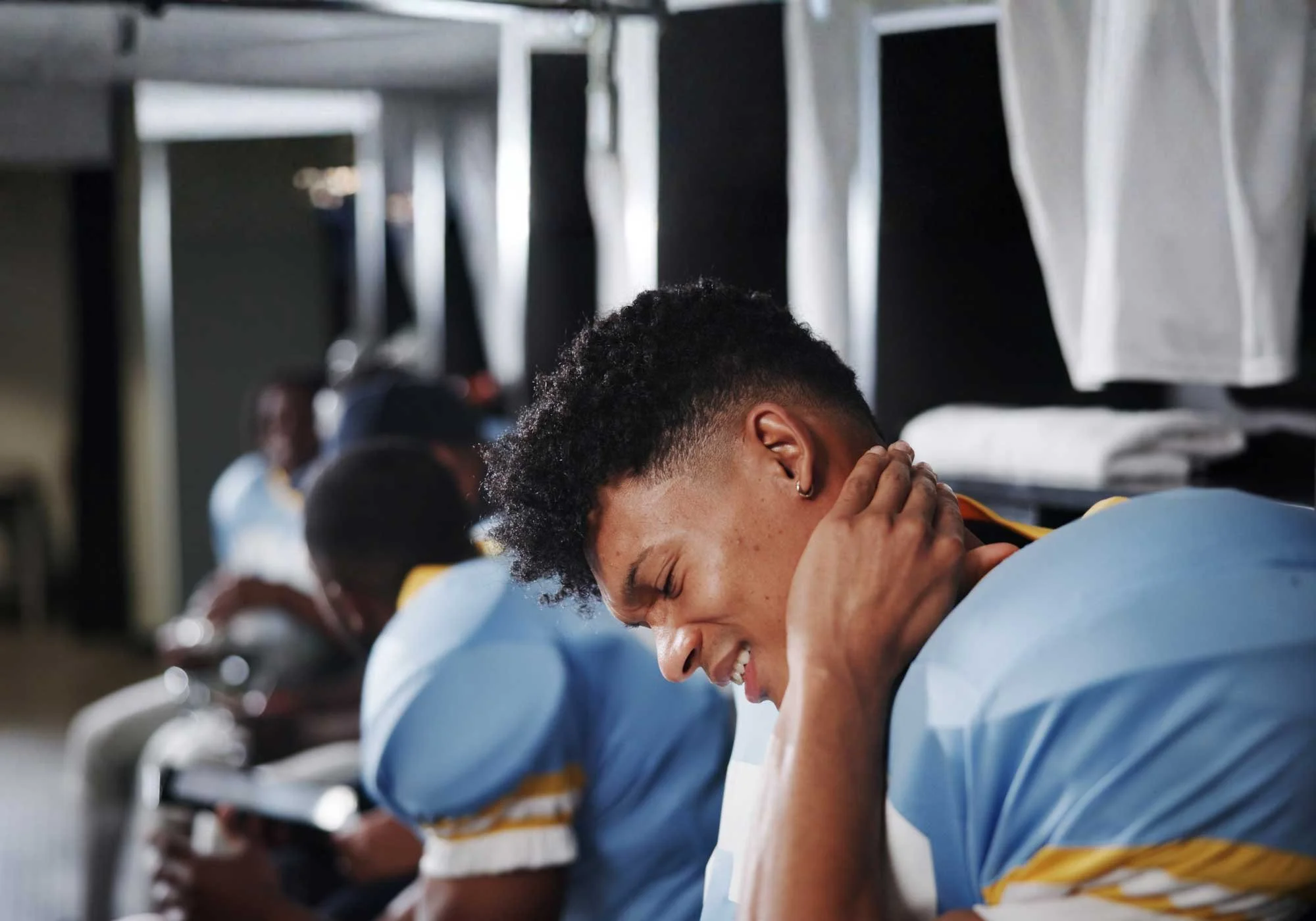 A man holding his neck in pain after getting a concussion from playing football