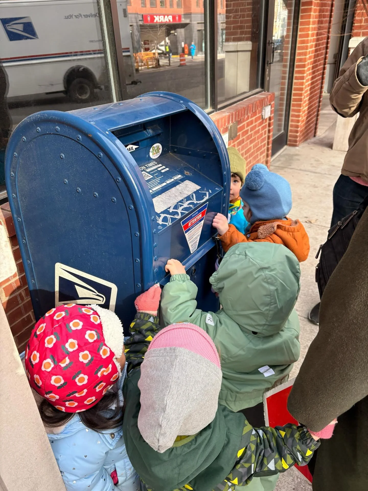 Our Clover (2s class) mail carriers are on a special delivery mission! The Clovers have been exploring the world of mail by addressing envelopes, adding stamps, writing letters, sorting postcards, and discovering how mail travels from one place to an