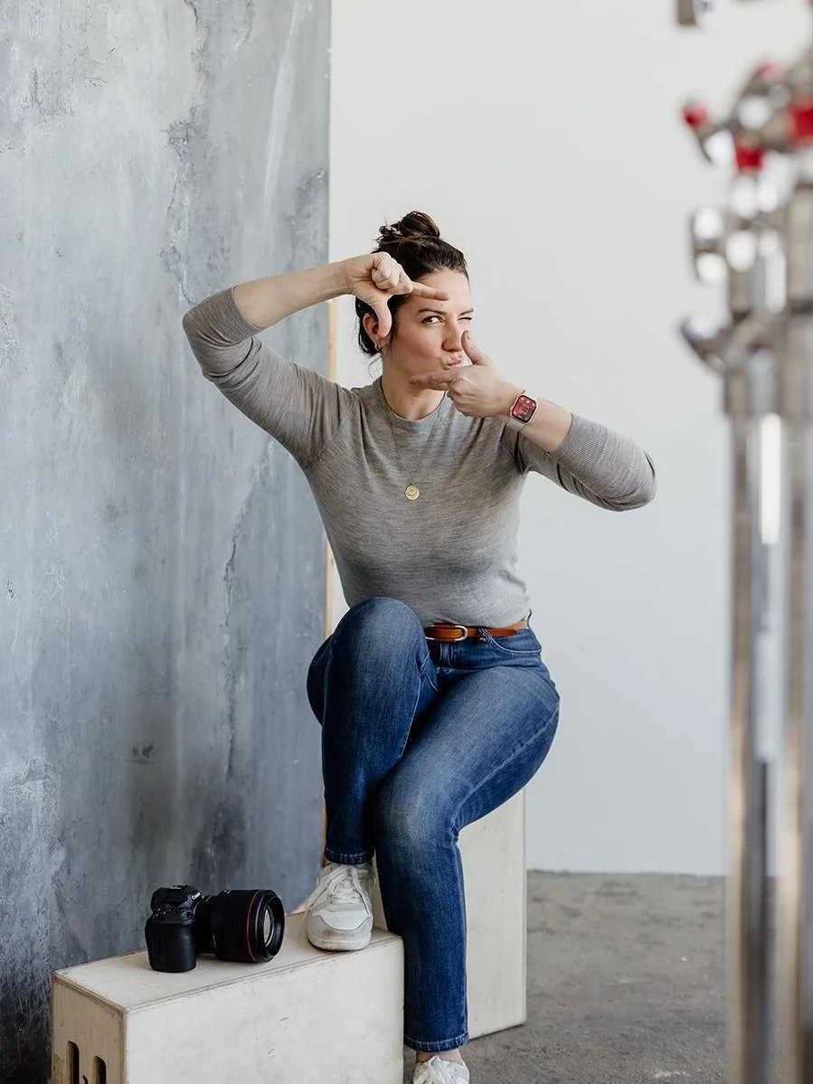 Mary Otañez seated in a sunlit studio with her camera