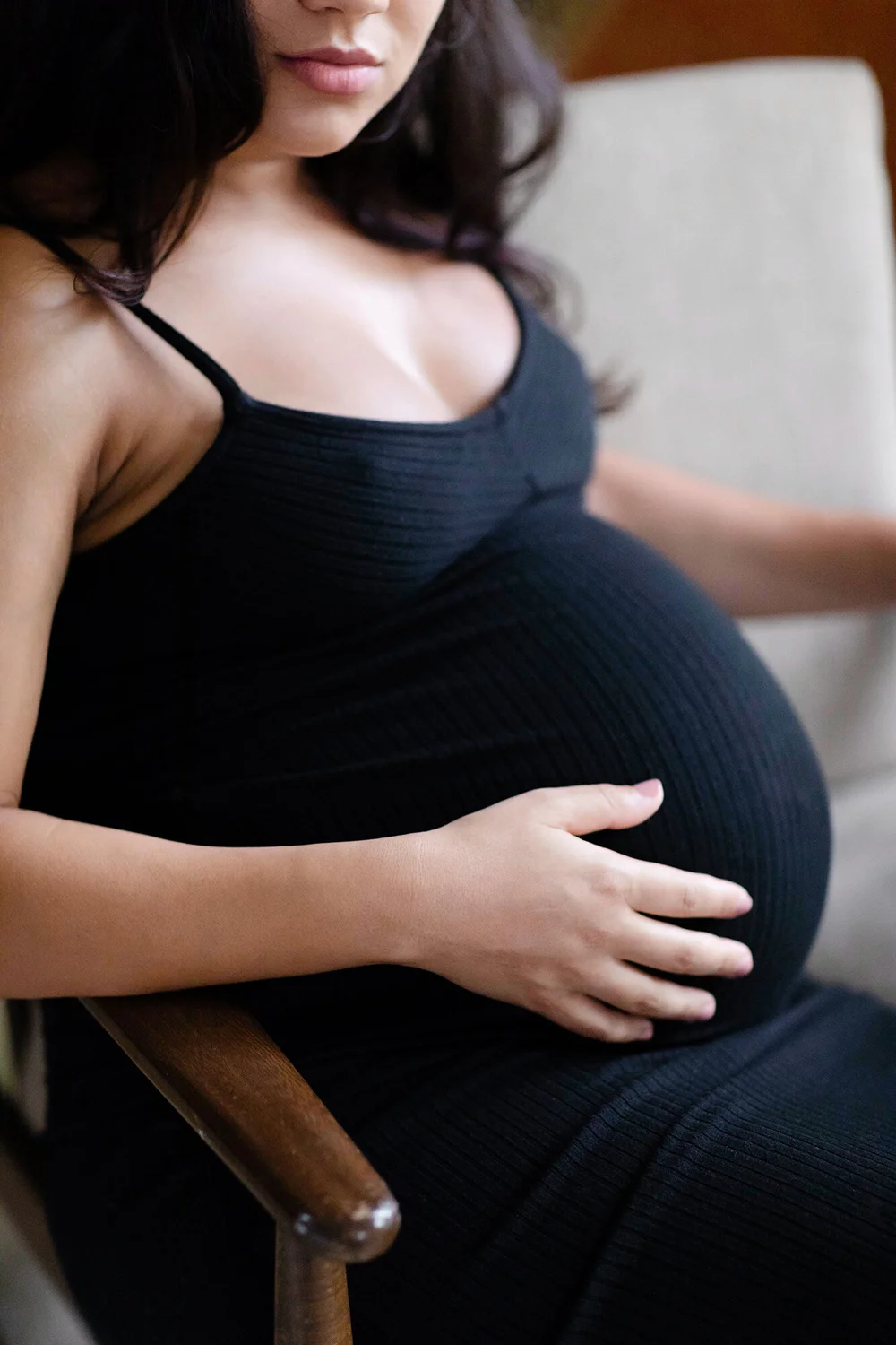 An intimate maternity portrait with a mother's hand resting on her belly