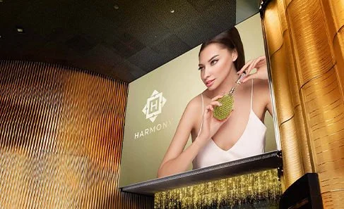 Large billboard featuring a woman in a white dress holding a green fruit, in a modern interior setting.