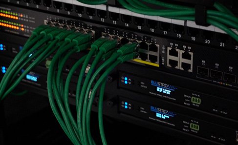 Close-up of a network switch with multiple green Ethernet cables connected.