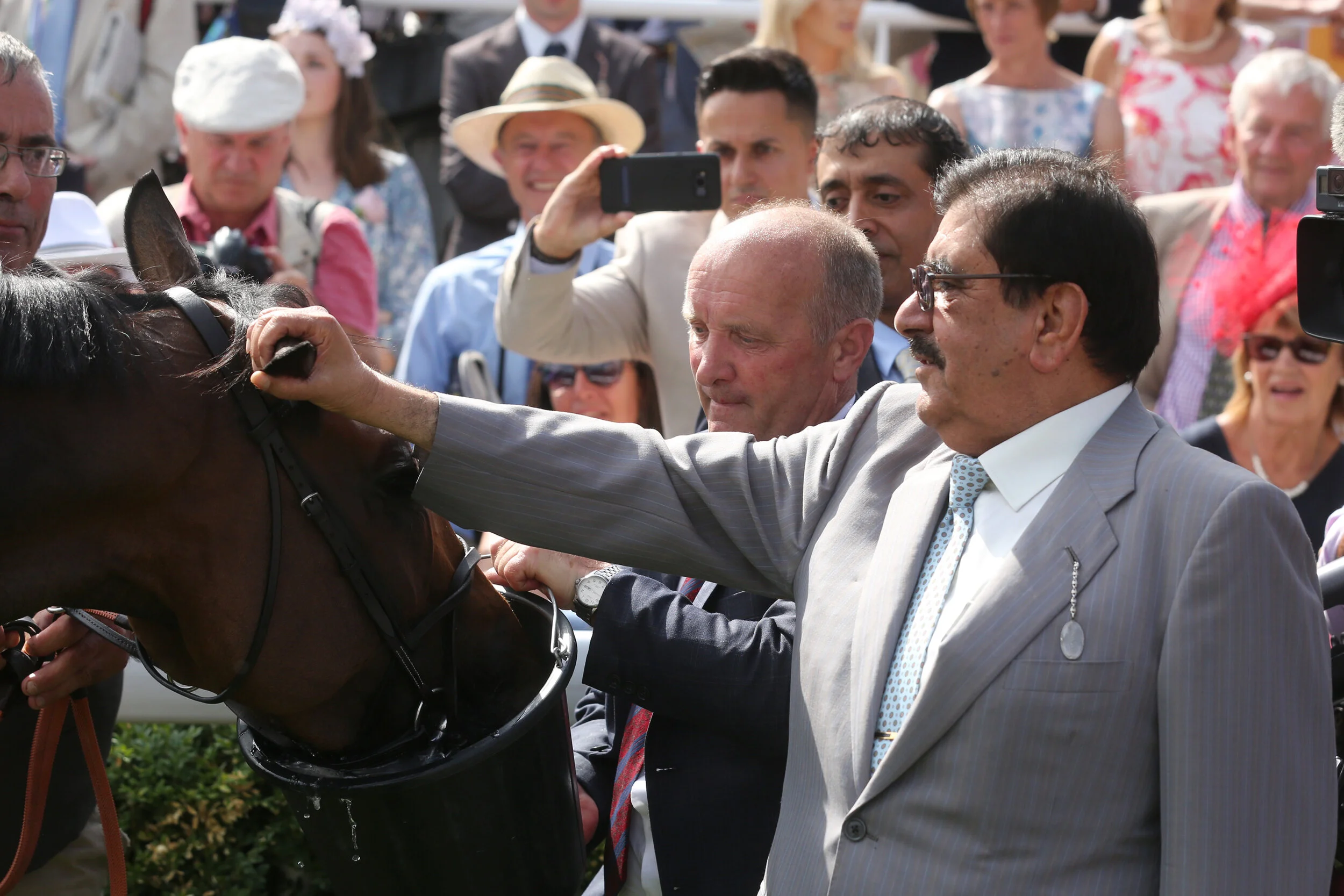 The late Sheikh Hamdan Al Maktoum with Travelling Head Lad Geoff Snook giving Battaash a drink after the King George