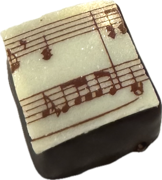 dark chocolate square with white chocolate sheet music topper