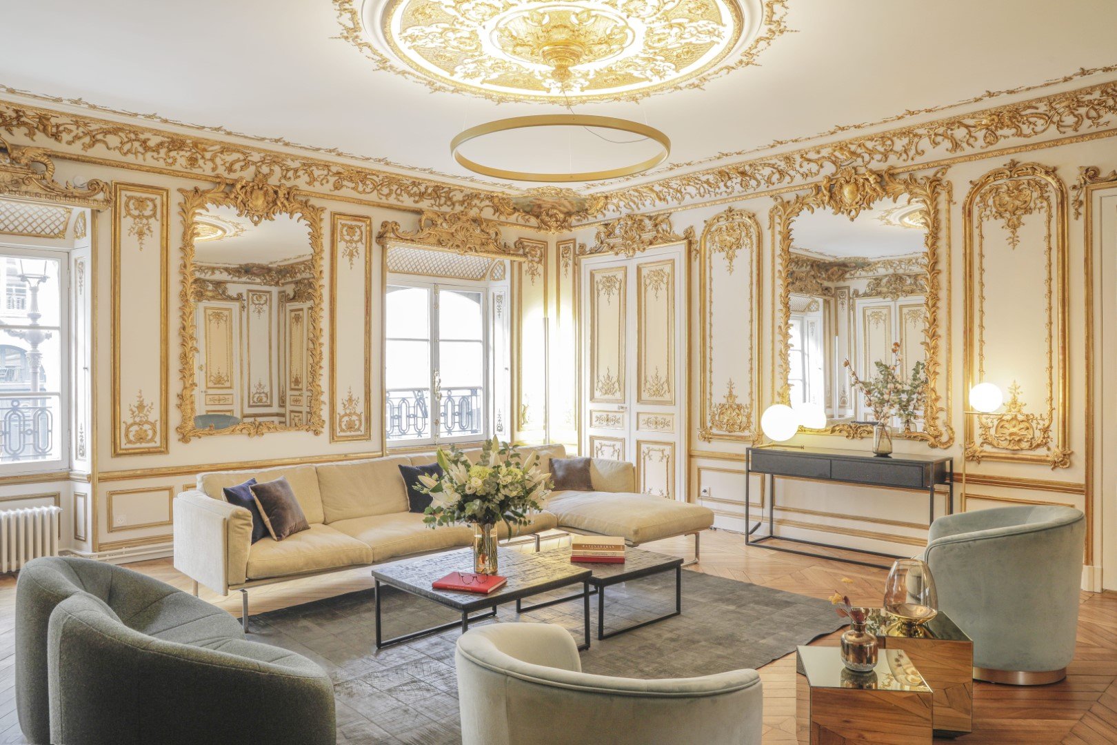 Appartement de luxe avec un salon majestueux avec des moulures dorées sur les murs et au plafond à Paris 