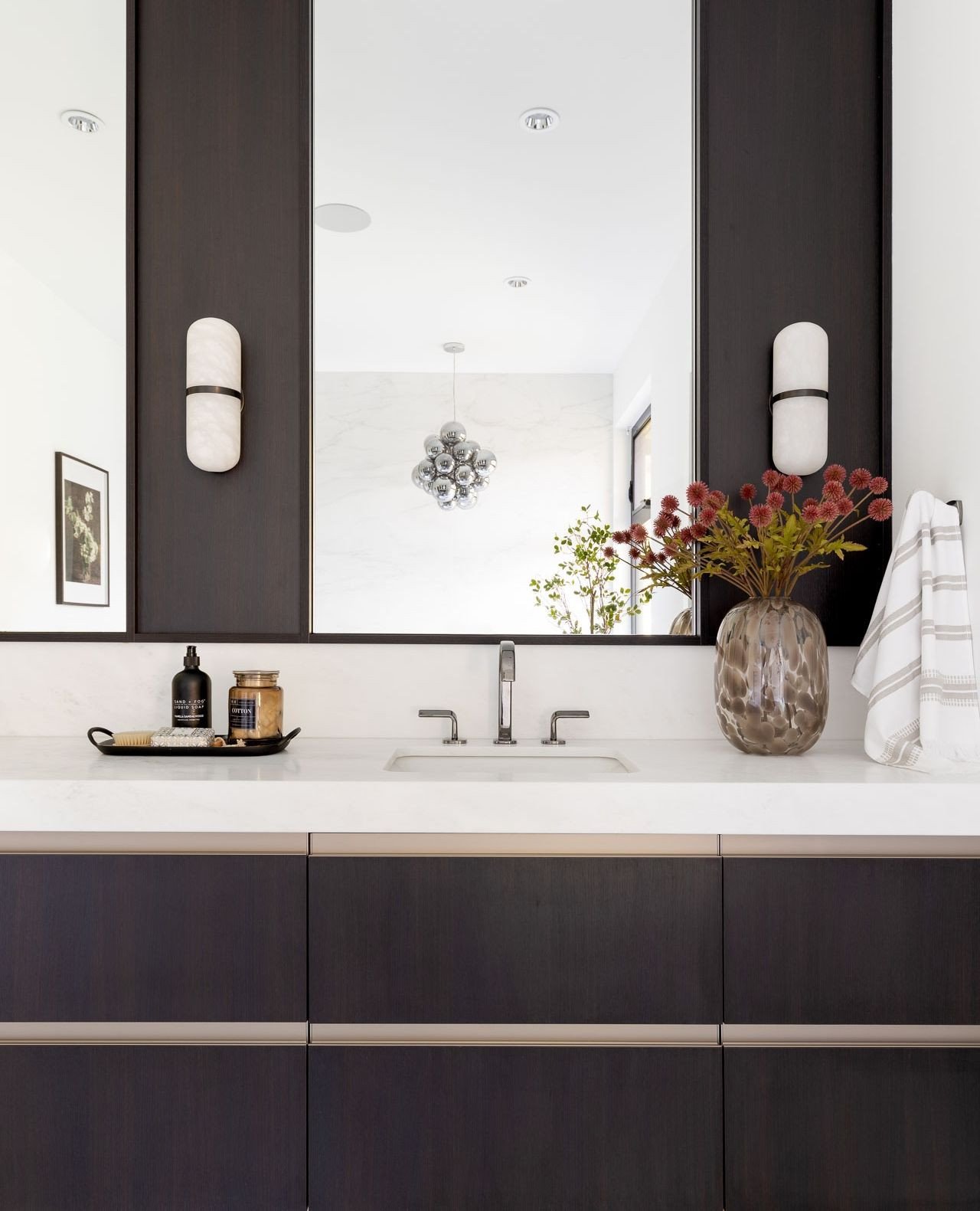 Dark stained oak, integrated metal pulls, and contrasting leathered marble in the primary ensuite at #ForestModern